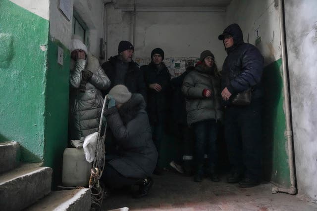 <p> La gente se refugia de los bombardeos en la entrada de un edificio de apartamentos en Mariúpol   </p>