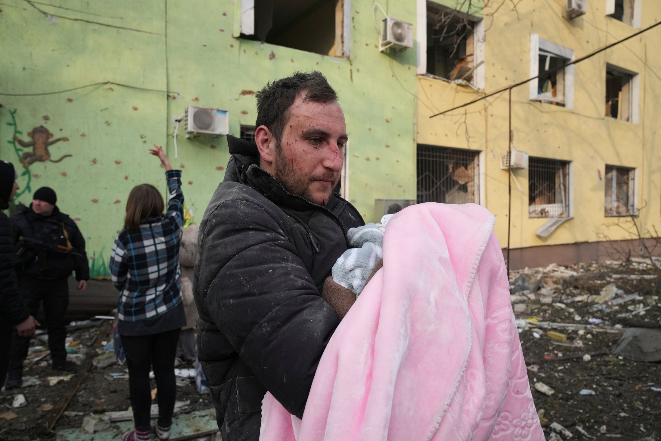 A man holds a baby during an evacuation from a maternity hospital struck in a shelling attack in Mariupol