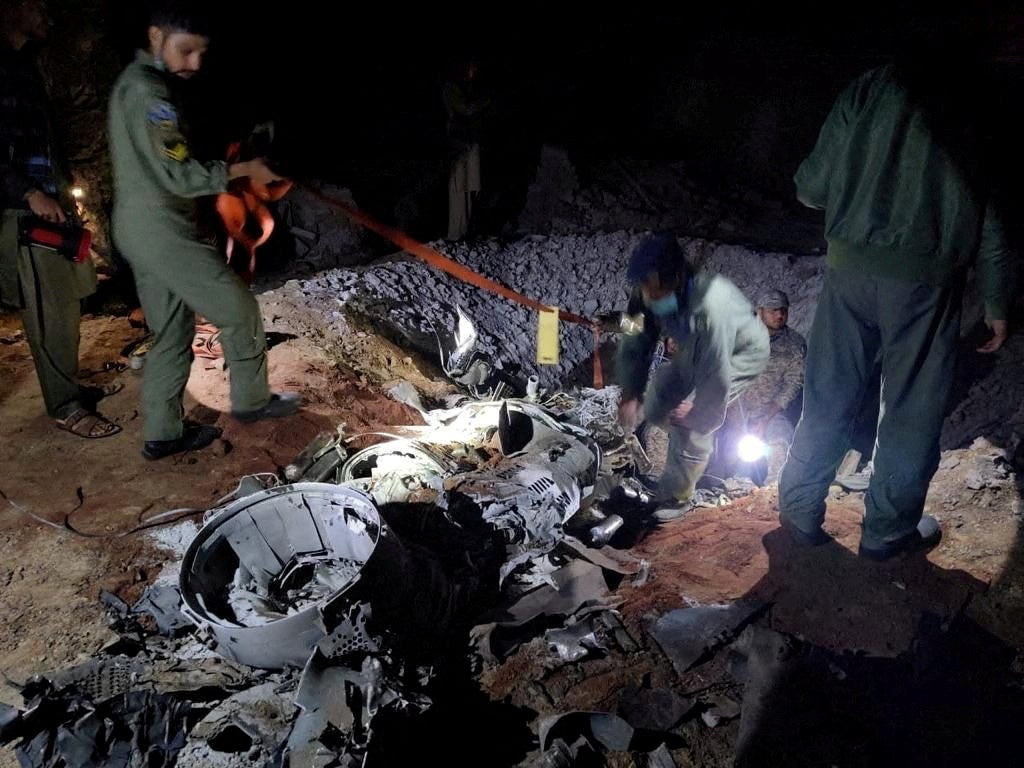 People work around what Pakistani security sources say is the remains of a missile fired into Pakistan from India, near Mian Channu, Pakistan, March 9