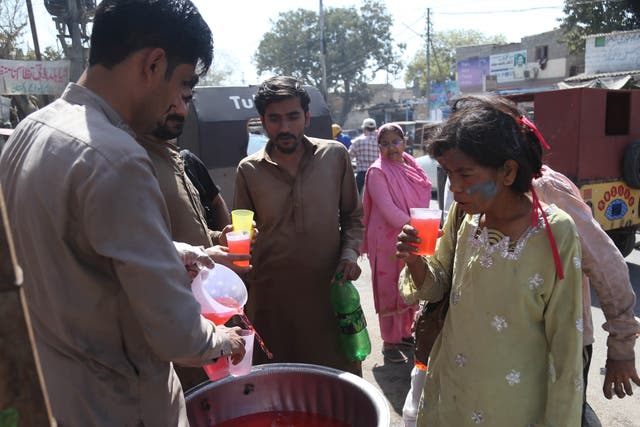 <p>People drink free juice on the roadside, to beat the heat in Karachi, Pakistan, on 15 March. The Pakistan Meteorological Department (PMD) warned of an extreme heat wave across the country</p>