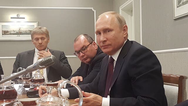 Russian president Vladimir Putin with Dimitry Peskov (Clive Marshall/PA)
