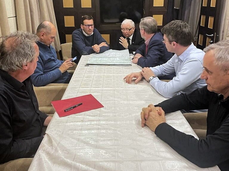 Janez Jansa, Mateusz Morawiecki and Petr Fiala talk over a map in a train to Kyiv