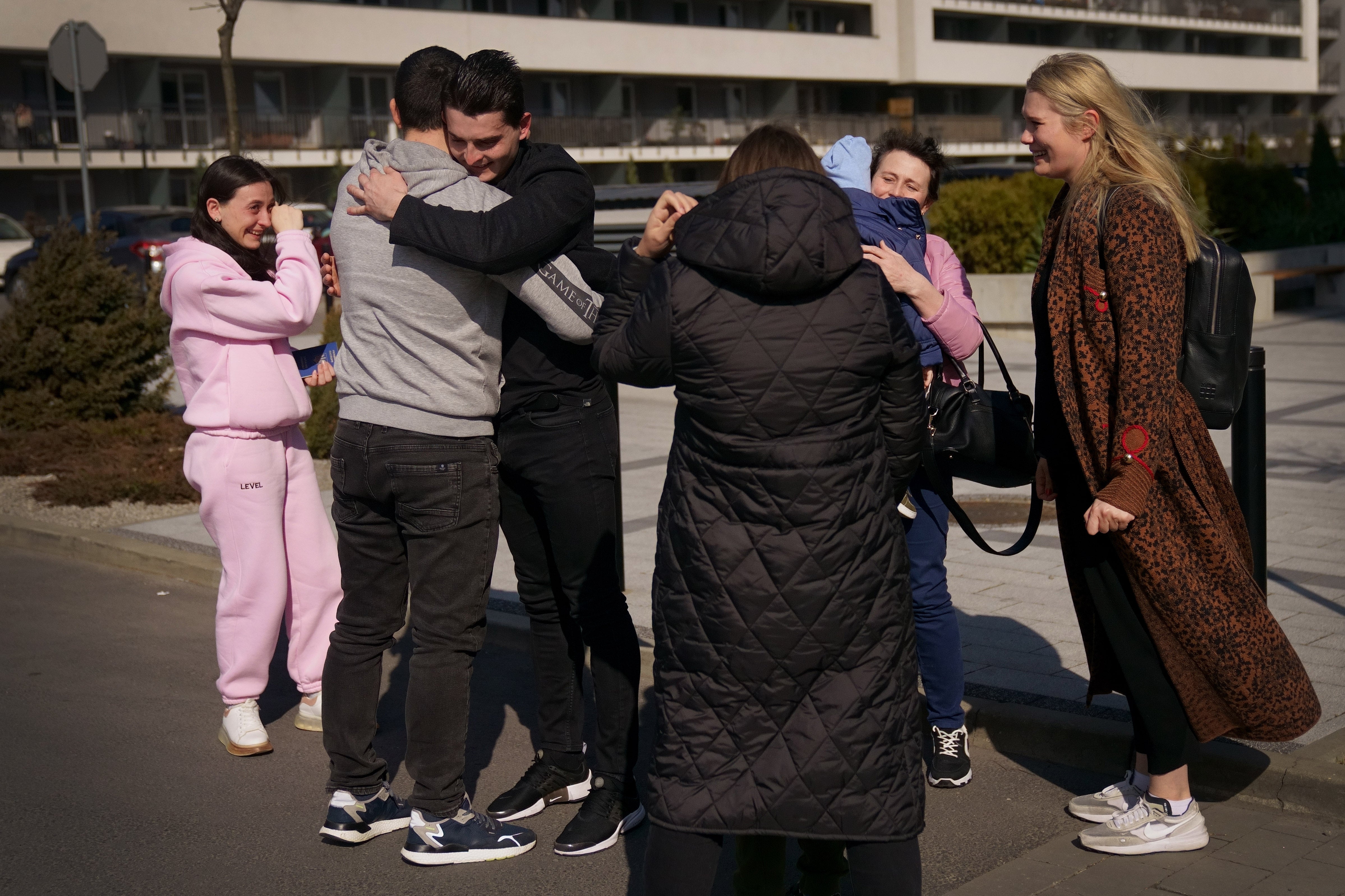 Ukrainian-born Vasyl Kucherka (third left) hugs his brother Misha Kucherka, as his sister, sister-in-law, son, mother, and partner (right) watch on in Rzeszow, Poland