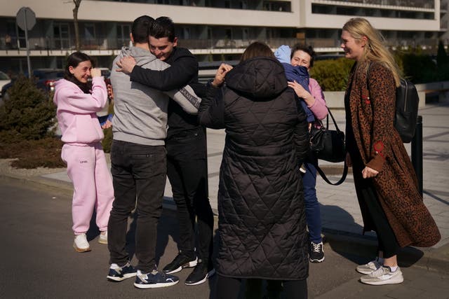 <p>Ukrainian-born Vasyl Kucherka (third left) hugs his brother Misha Kucherka, as his sister, sister-in-law, son, mother, and partner (right) watch on in Rzeszow, Poland </p>