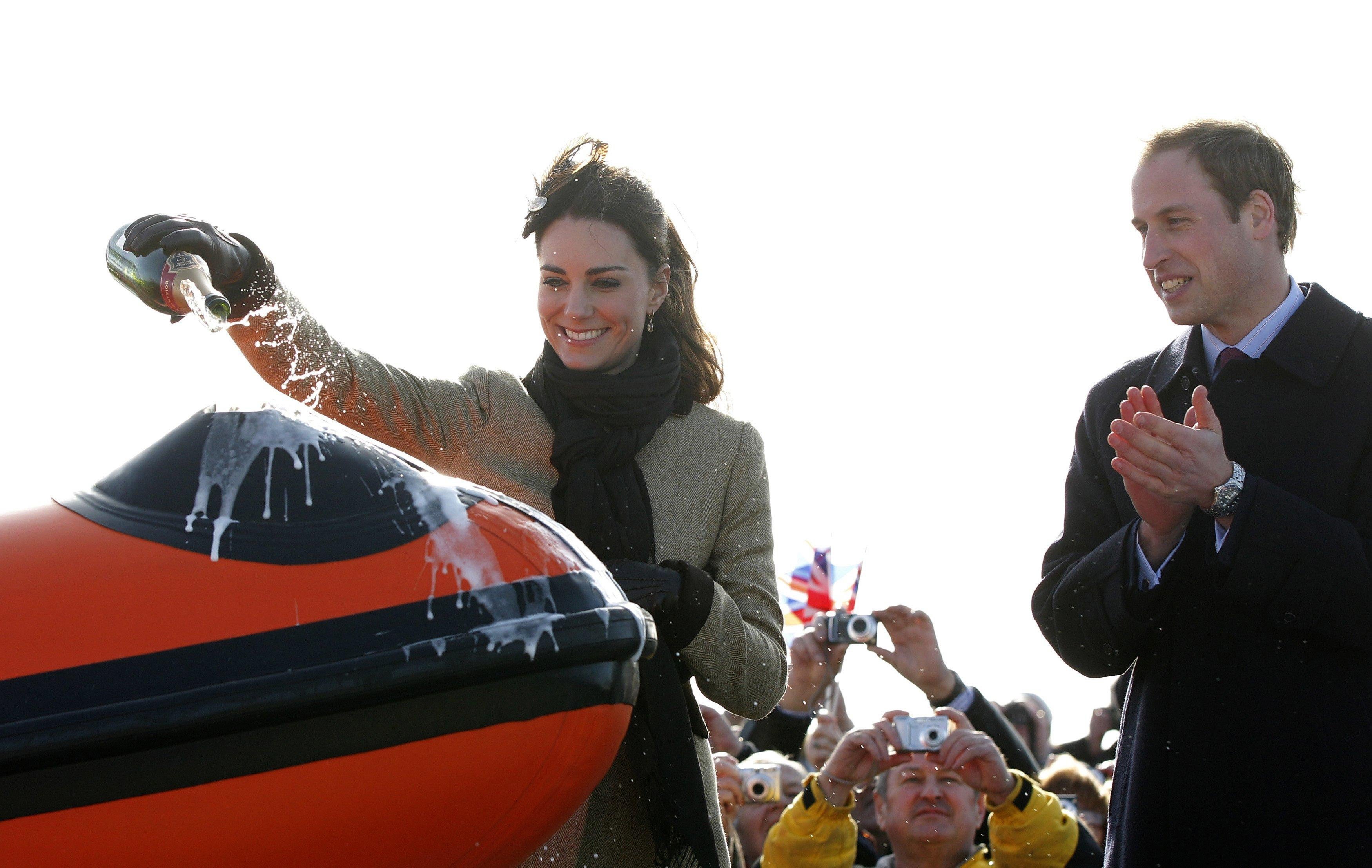 William watches fiancee Kate pour champagne at Trearddur Bay Lifeboat Station on Anglesey in 2011 ahead of their wedding (Phil Noble/PA)