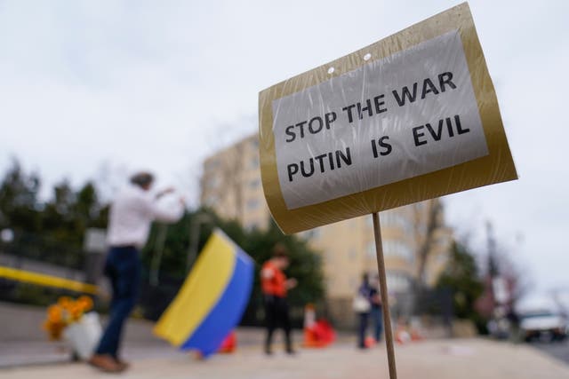 A sign that reads “STOP THE WAR PUTIN IS EVIL” is seen as supporters of Ukraine demonstrate with the yellow and blue flag of Ukraine in front of the Embassy of Russian Federation in Washington. (AP Photo/Carolyn Kaster/PA))