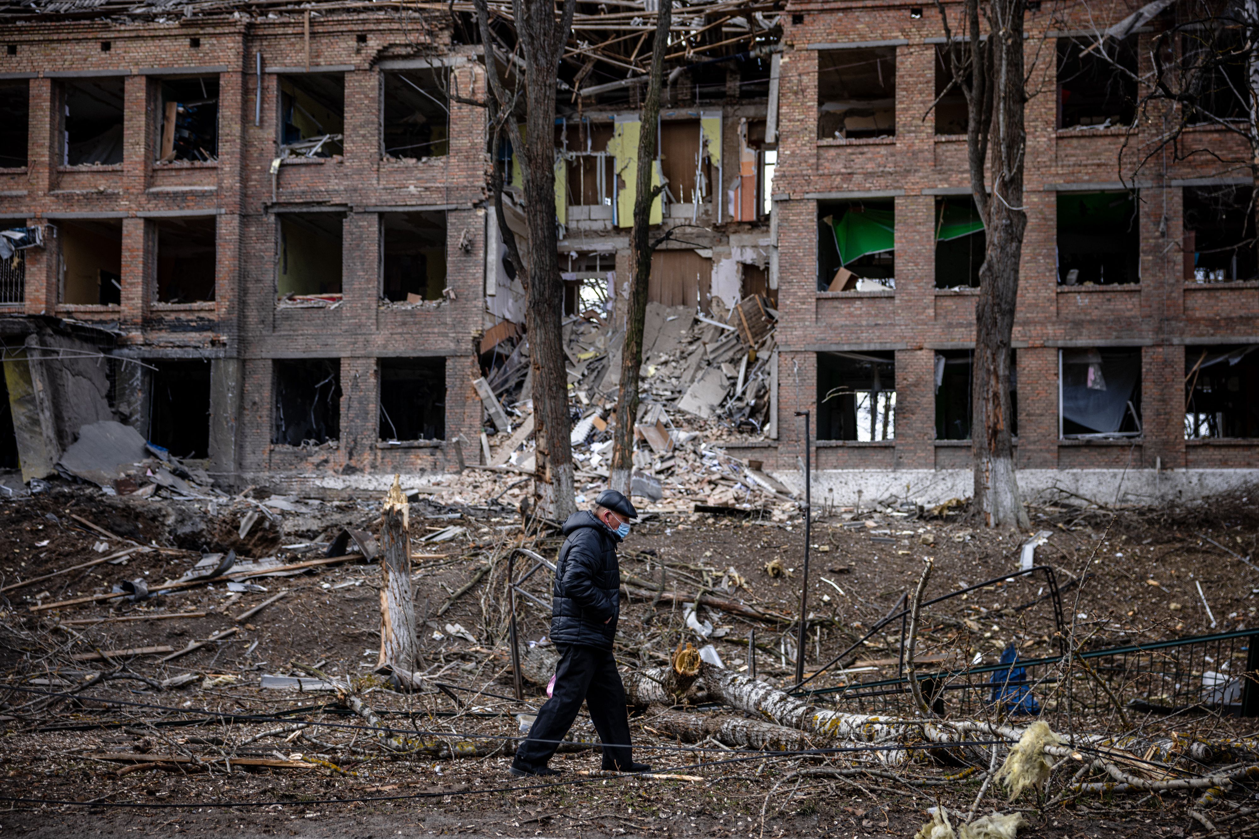 A man walks in front of a destroyed building after a Russian missile attack near Kyiv on 27 February