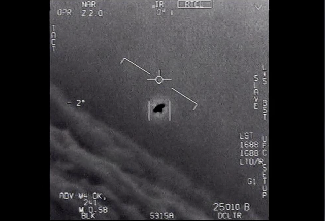 <p>The image released by the Pentagon from 2015 shows an unexplained object is seen at center as it is tracked as it soars high along the clouds</p>