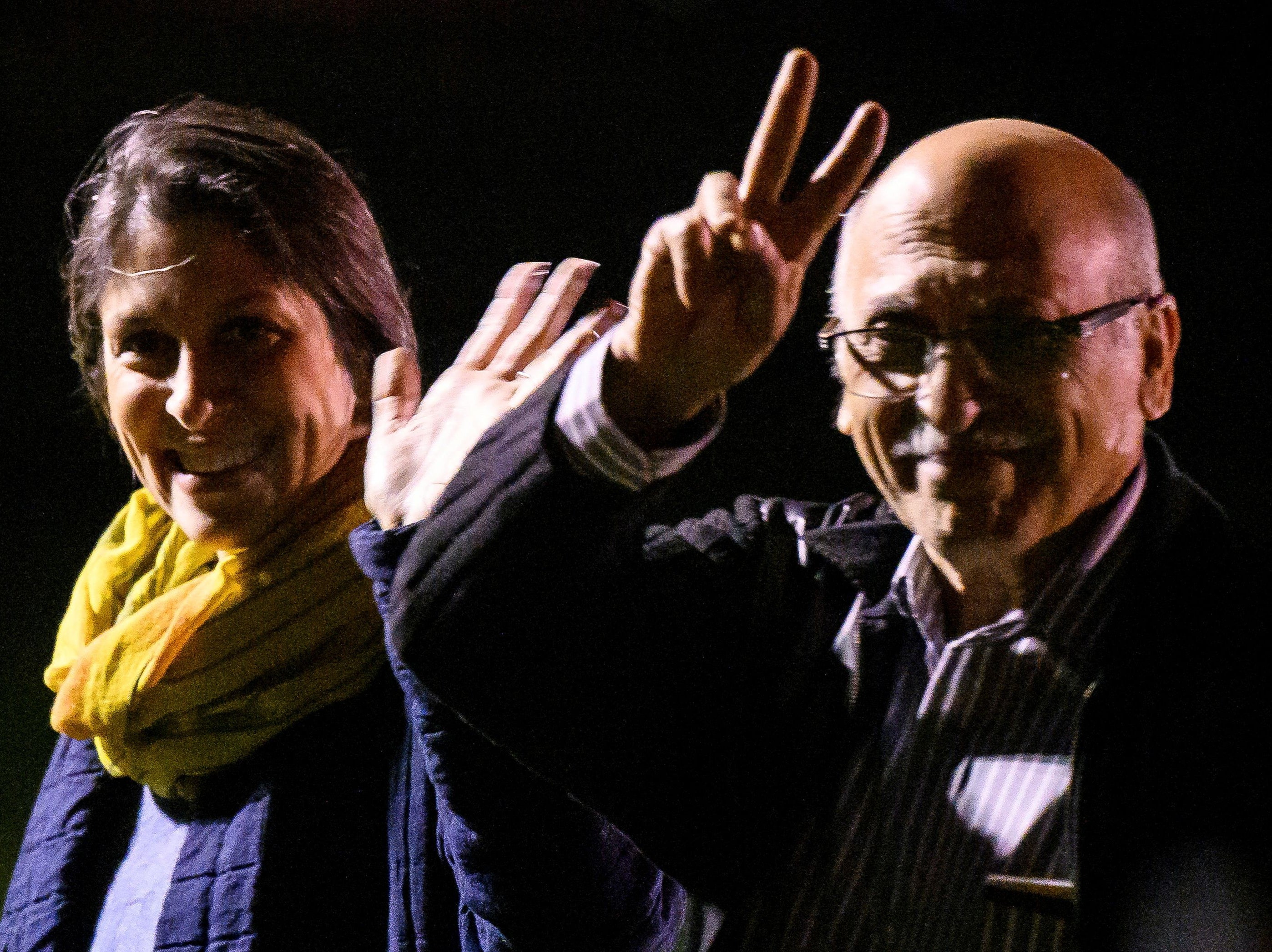 Nazanin Zaghari-Ratcliffe smiles and waves at cameras while fellow British-Iranian detainee Anoosheh Ashoori gives the peace sign after they arrive at RAF Brize Norton shortly after 1am