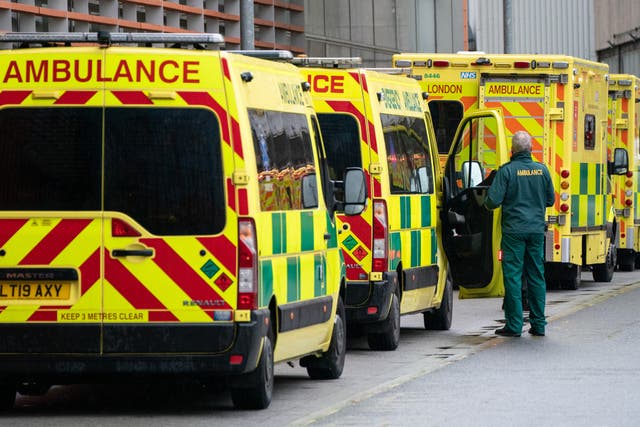 A paramedic walking past a line of ambulances in December 2021 (Dominic Lipinski/PA)