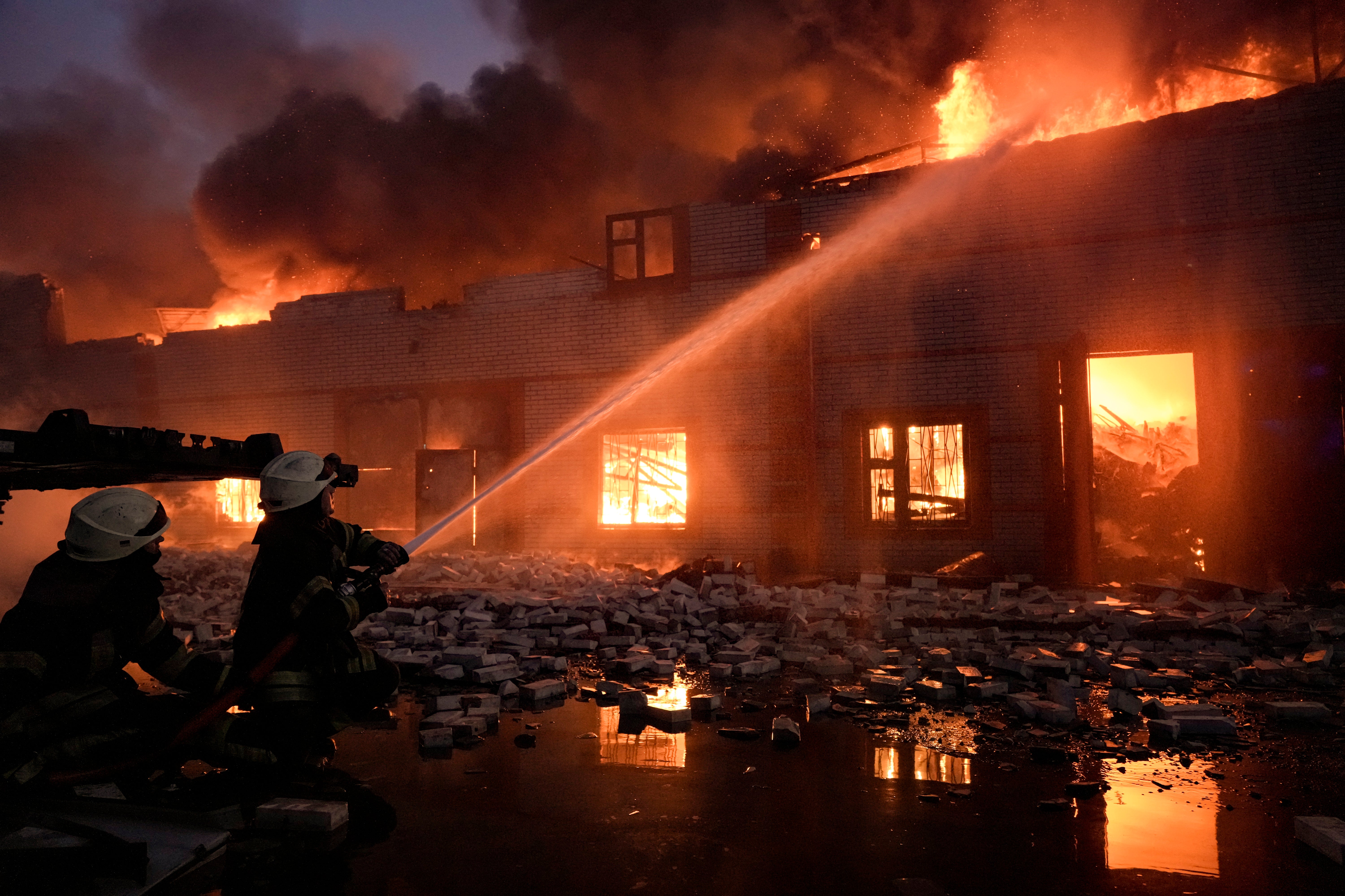 Ukrainian firefighters extinguish a blaze at a warehouse after a bombing on the outskirts of Kyiv, Ukraine, Thursday, March 17, 2022.