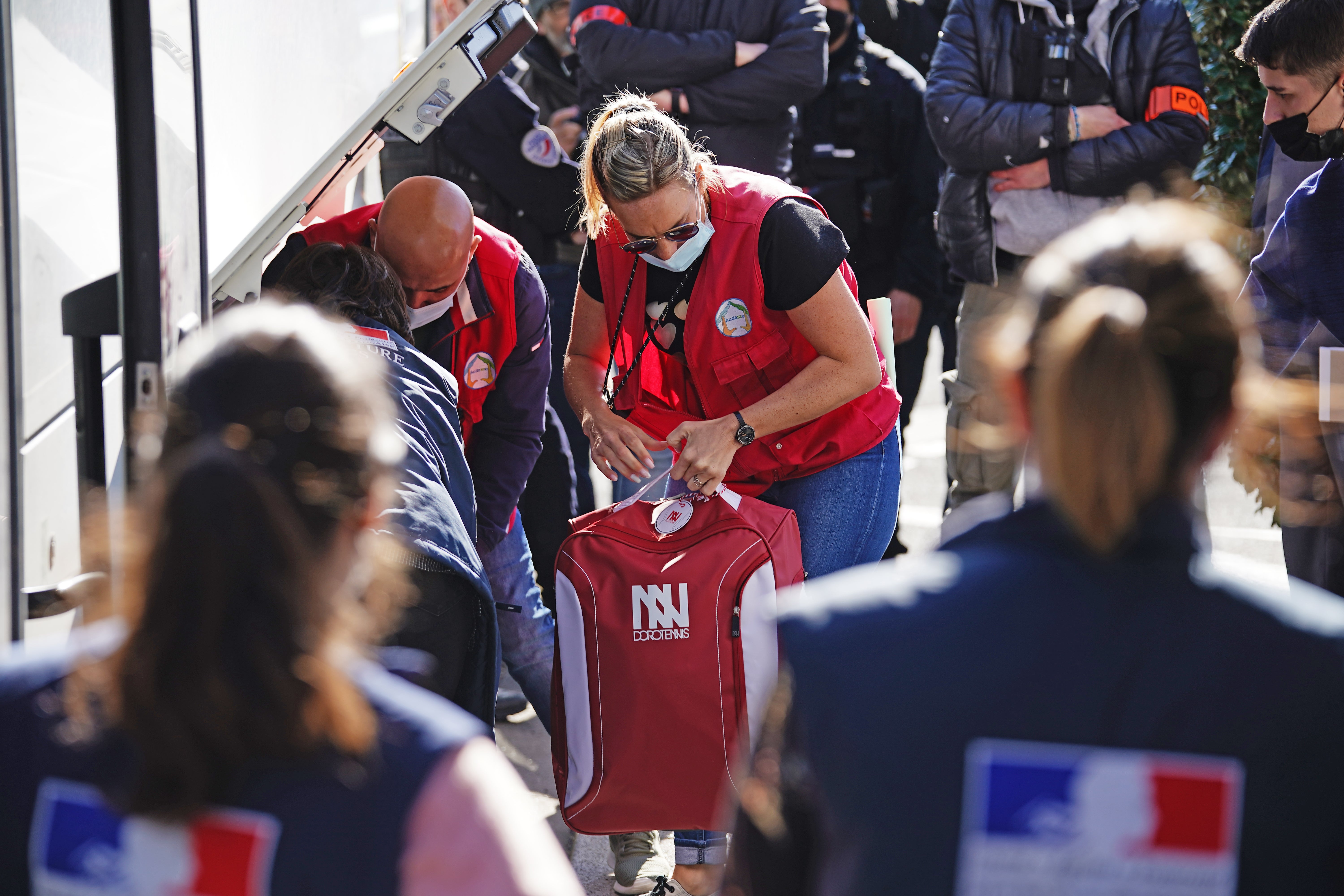 Volunteers help Ukrainian refugees loading their belongings onto a bus in Calais, France (PA)