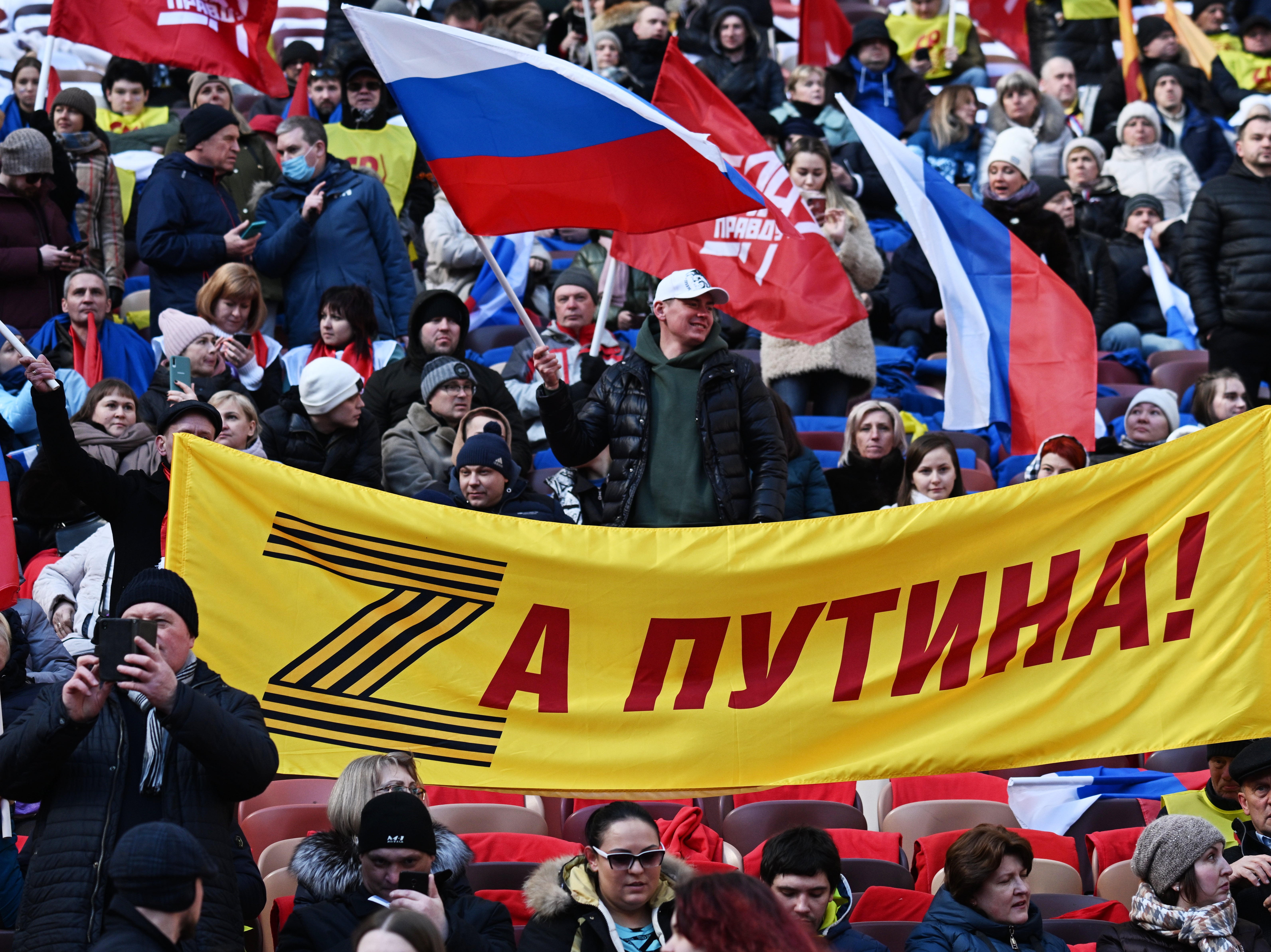 People hold a banner with letter Z and saying ‘For Putin!’