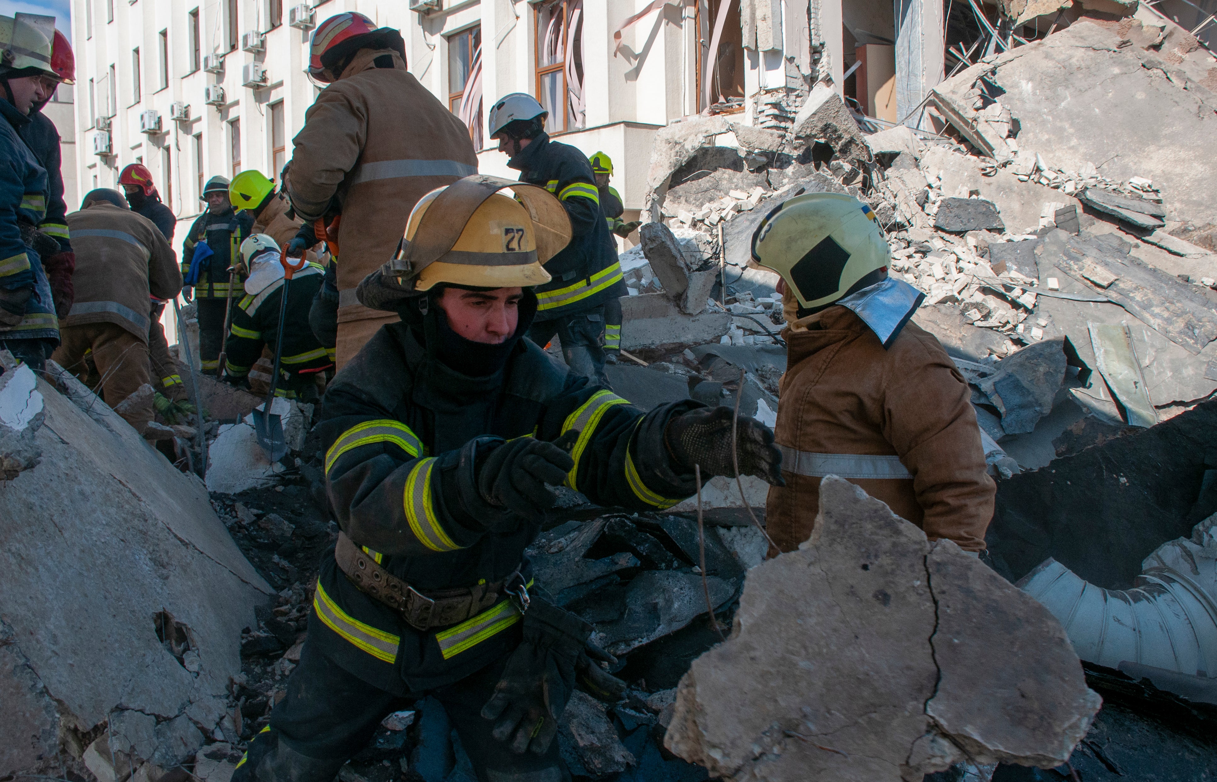 Ukrainian rescuers clean the debris of a shelled building in Kharkiv, Ukraine, 18 March 2022