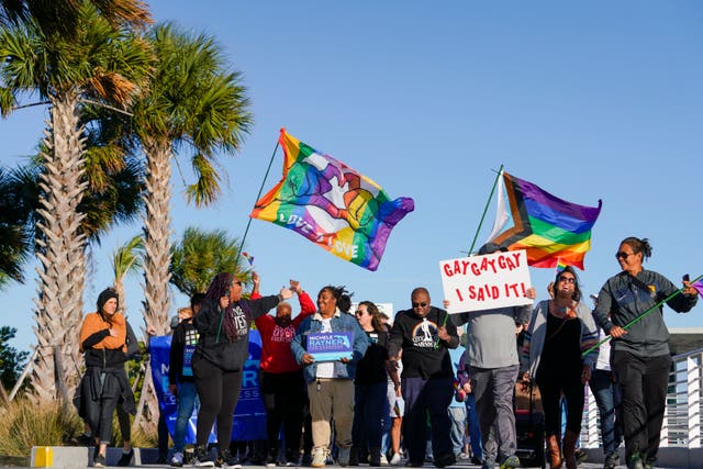 <p>Marchers wave flags as they walk at the St Pete Pier during a rally and march to protest against a bill dubbed by opponents as the ‘Don't Say Gay’ bill on 12 March 2022, in St Petersburg, Fla</p>