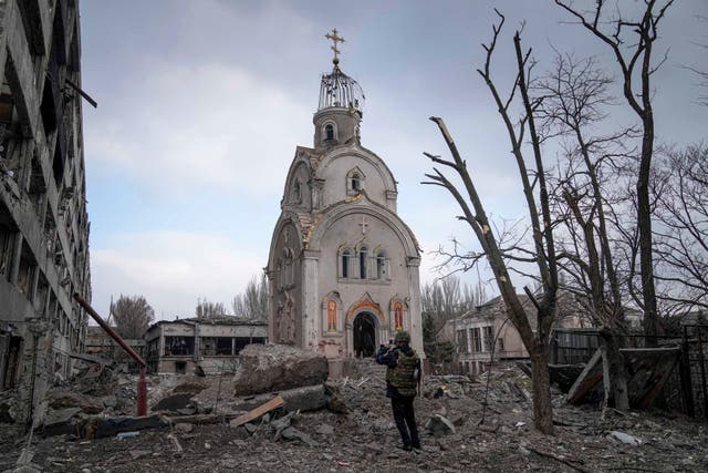 <p>A Ukrainian serviceman takes a photograph of a damaged church after shelling in a residential district in Mariupol, 10 March 2022</p>