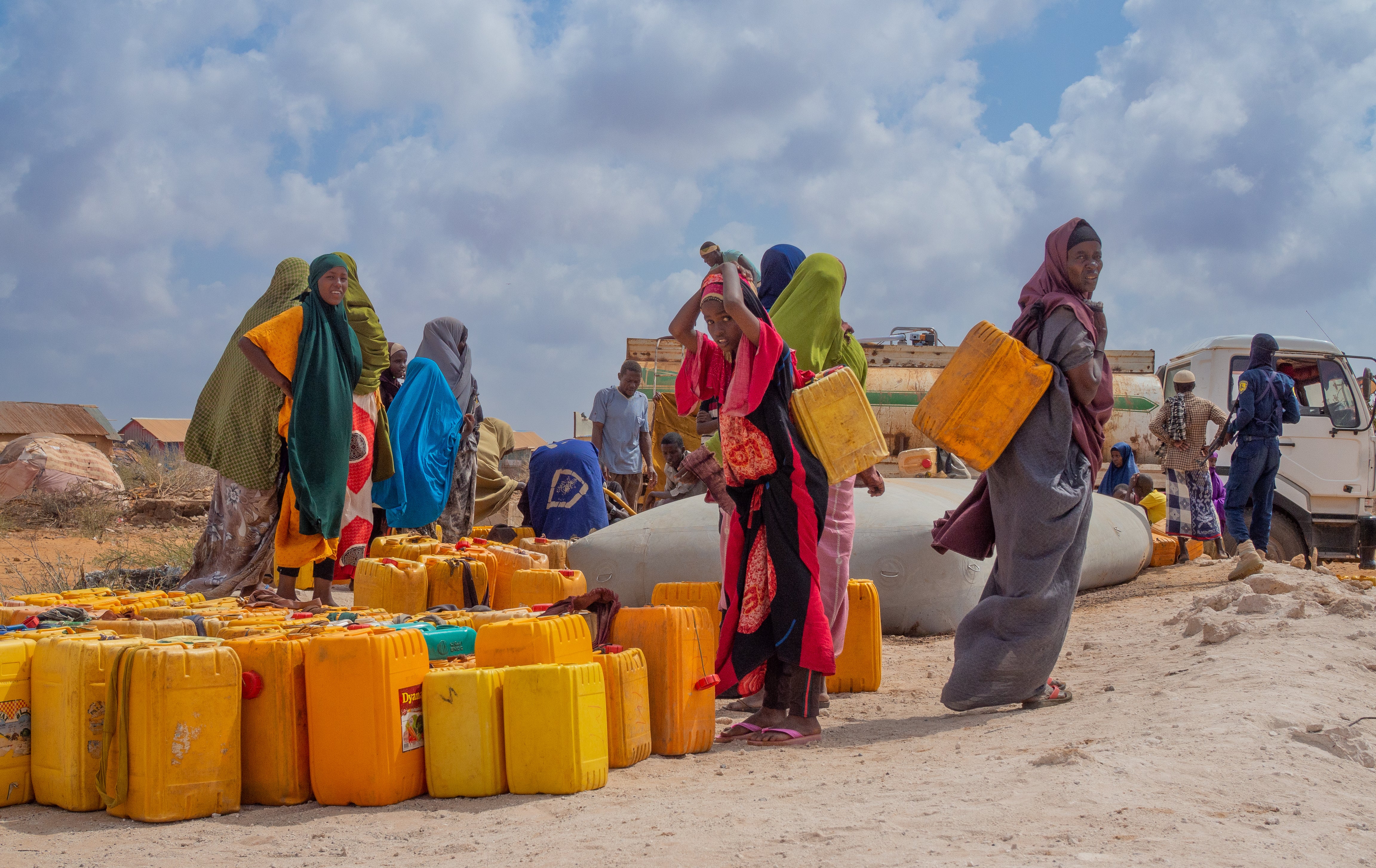 Women collect water dispensed by a truck at Luglow camp in southern Somalia’s Jubaland region