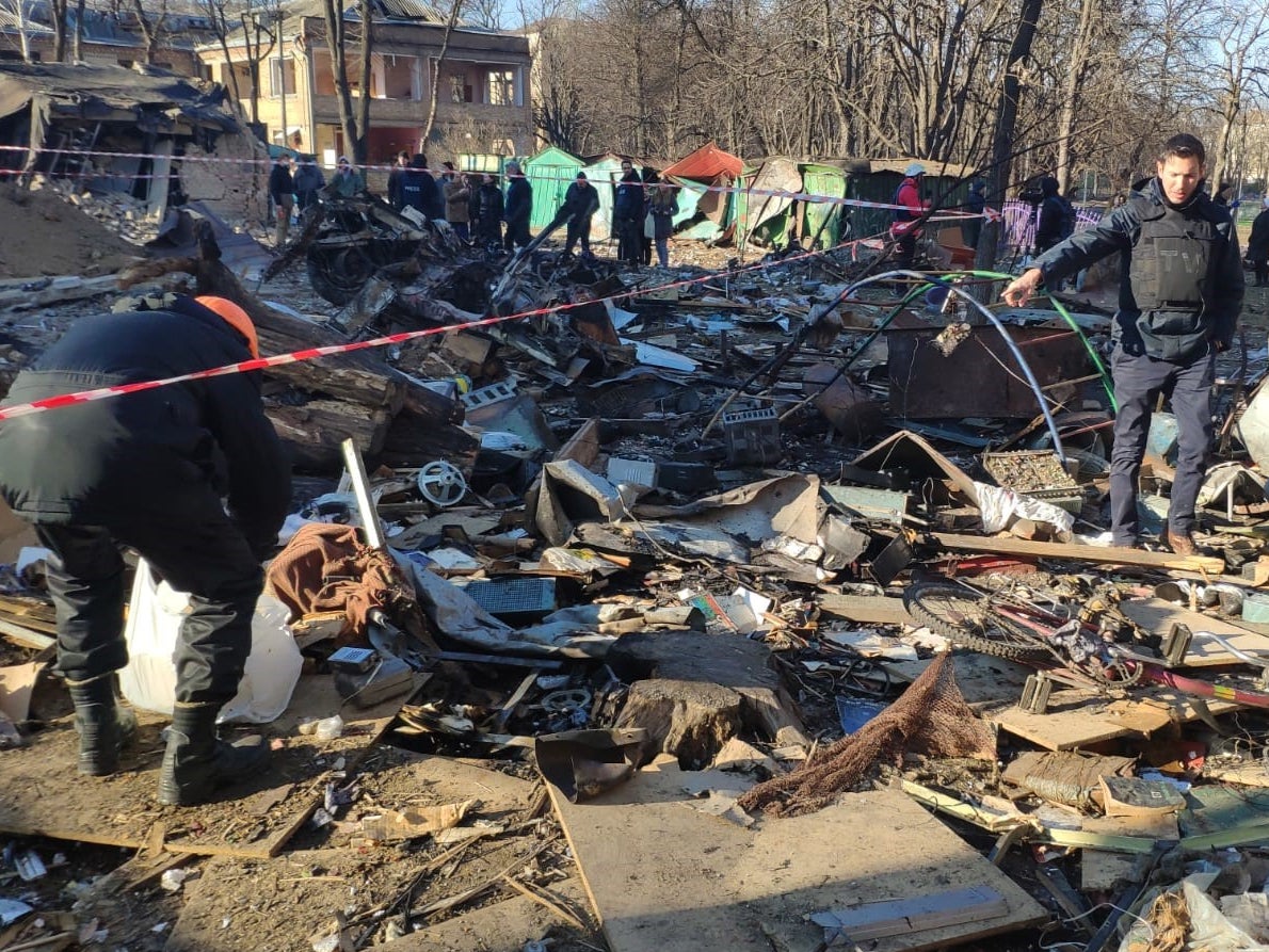 Men clear up rubble after early morning barrages hit the Podil neighbourhood of Kyiv, 18 March 2022