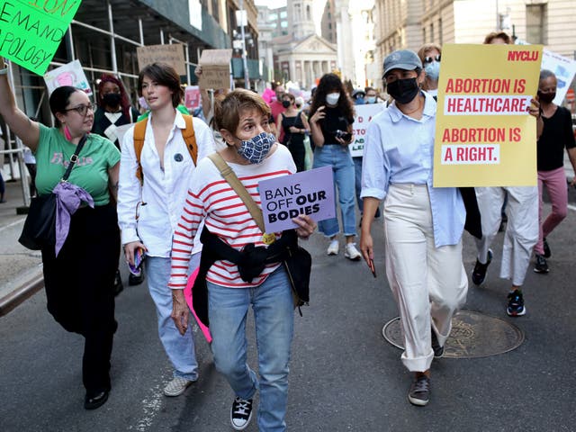 <p>Crowds march toward Washington Square Park for the Women's March on October 2, 2021 in New York City</p>