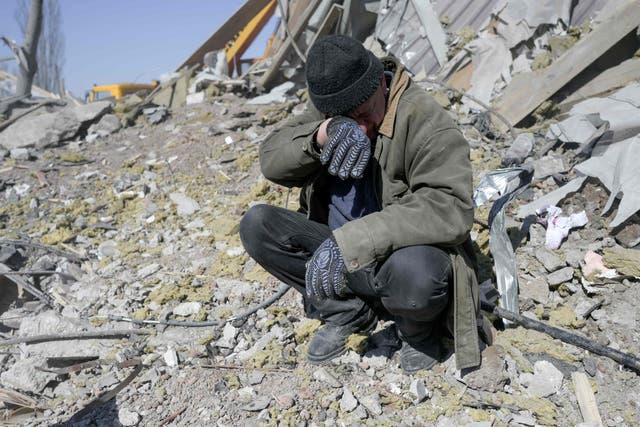<p>A man searches the rubble of barracks in Mykolaiv hit by a Russian airstrike</p>