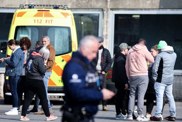<p>Witnesses and relatives of victims outside a sports hall that was turned into an emergency centre for medical and police support</p>