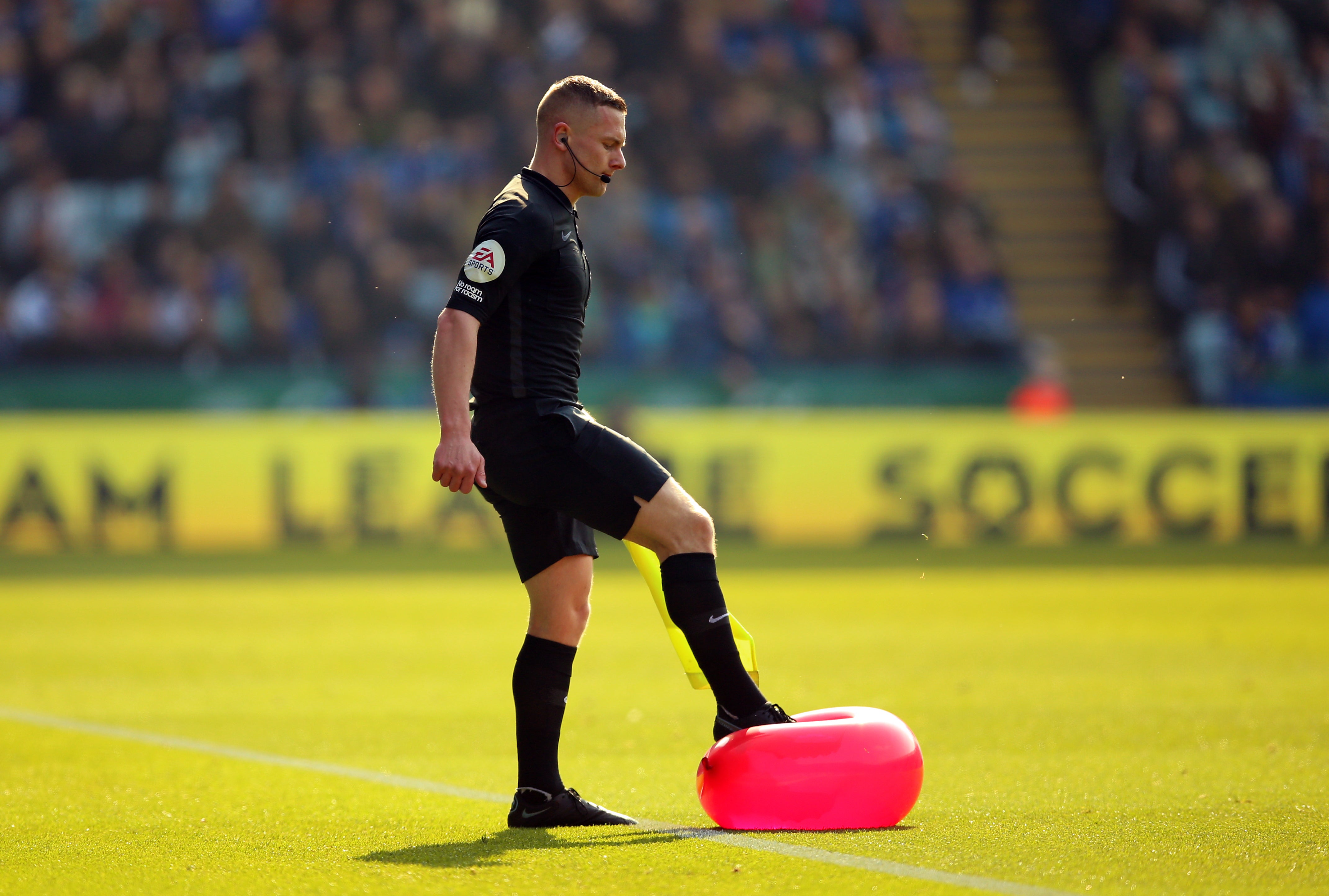 Assistant referee Wade Smith bursts a balloon thrown onto the pitch (Nigel French/PA)