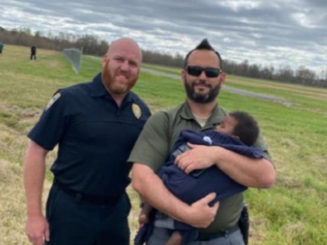 <p>Baton Rouge police officers with an eight-month-old infant who had gone missing overnight</p>