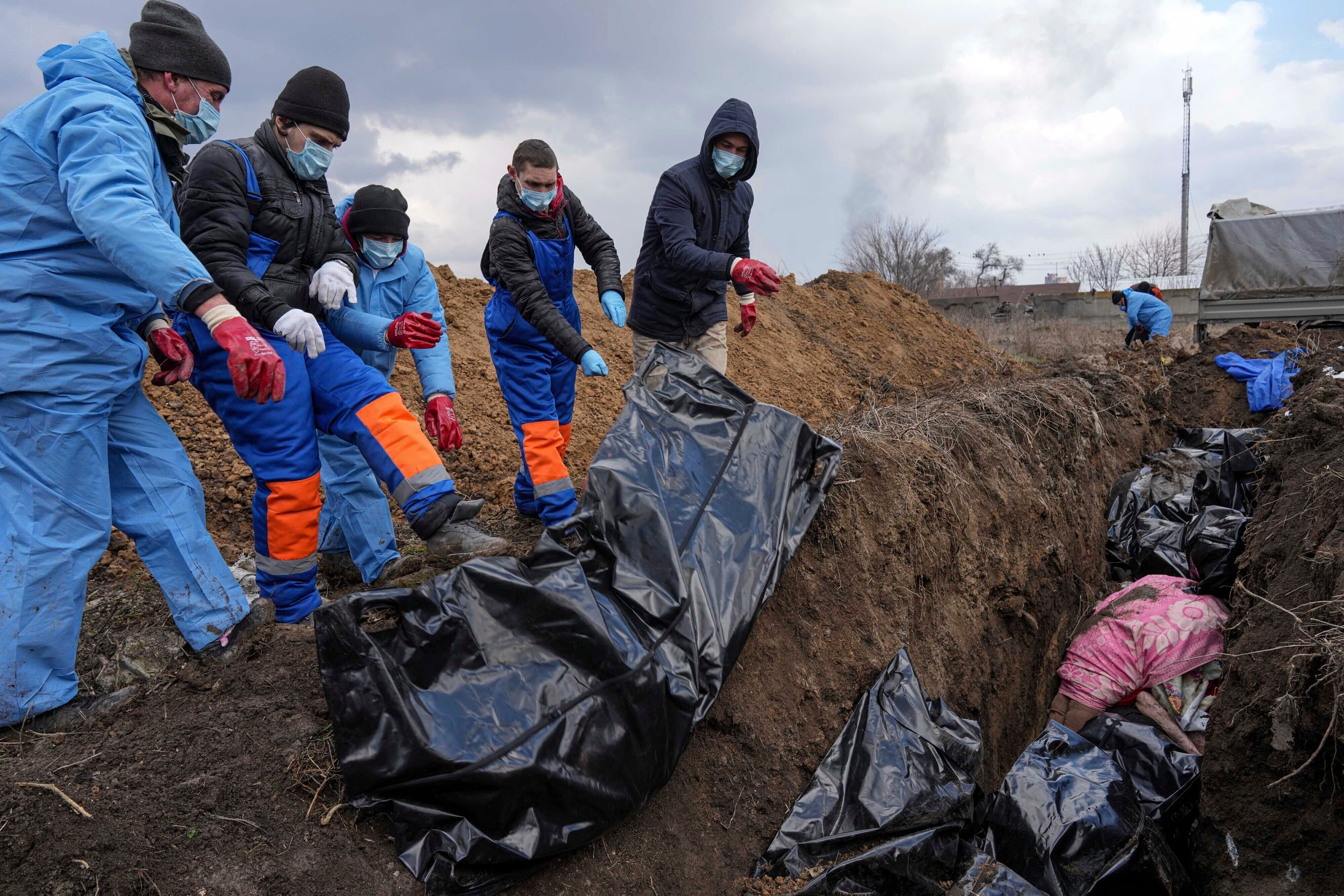 Dead bodies are placed into a mass grave on the outskirts of Mariupol, Ukraine on 9 March