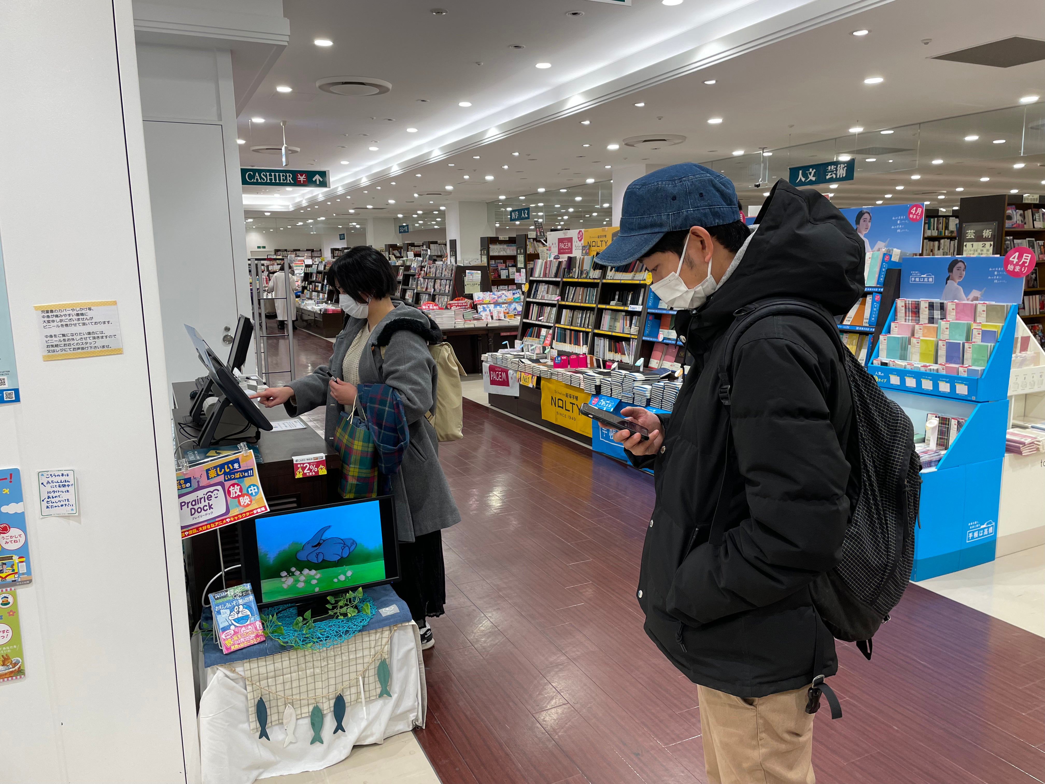 Akari Shirai buys a copy of Morimoto’s book as he stands nearby