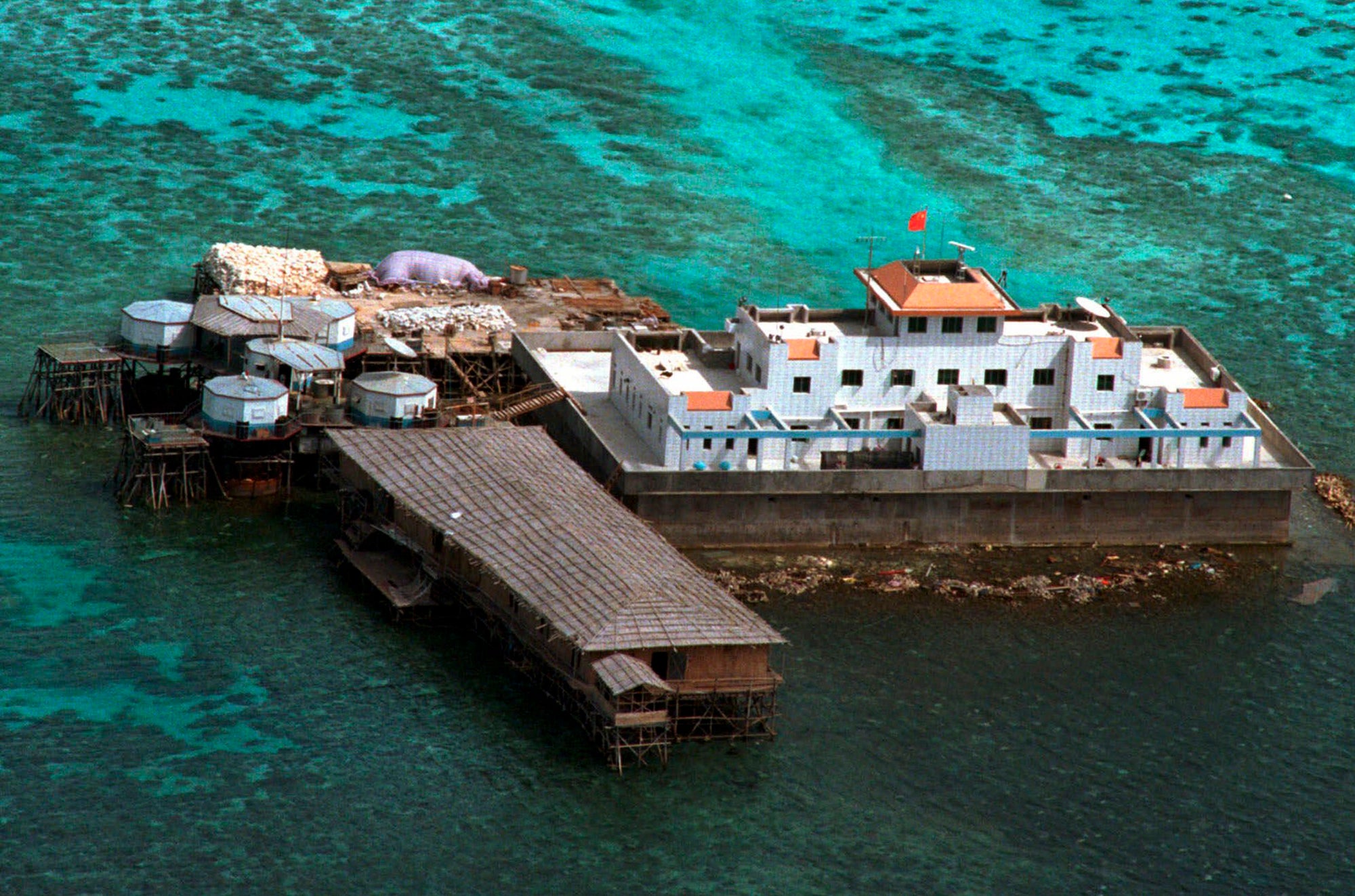 A Chinese flag flies from one of the two newly-finished concrete structures on the Mischief Reef off the disputed Spratly group of islands in the South China Sea in this aerial photo taken on Monday, 8 Feb 1999