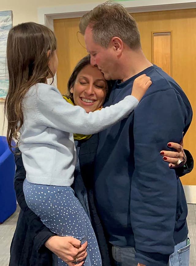 <p>Nazanin Zaghari-Ratcliffe hugs her husband and daughter upon her arrival at RAF Brize Norton</p>
