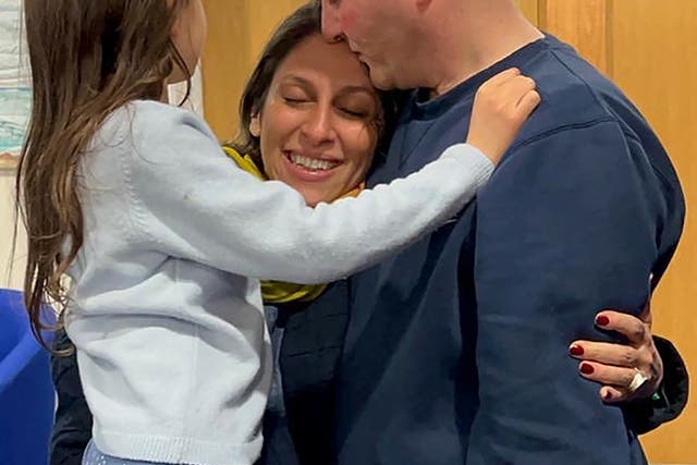 <p>Nazanin Zaghari-Ratcliffe hugs her husband and daughter upon her arrival at RAF Brize Norton</p>