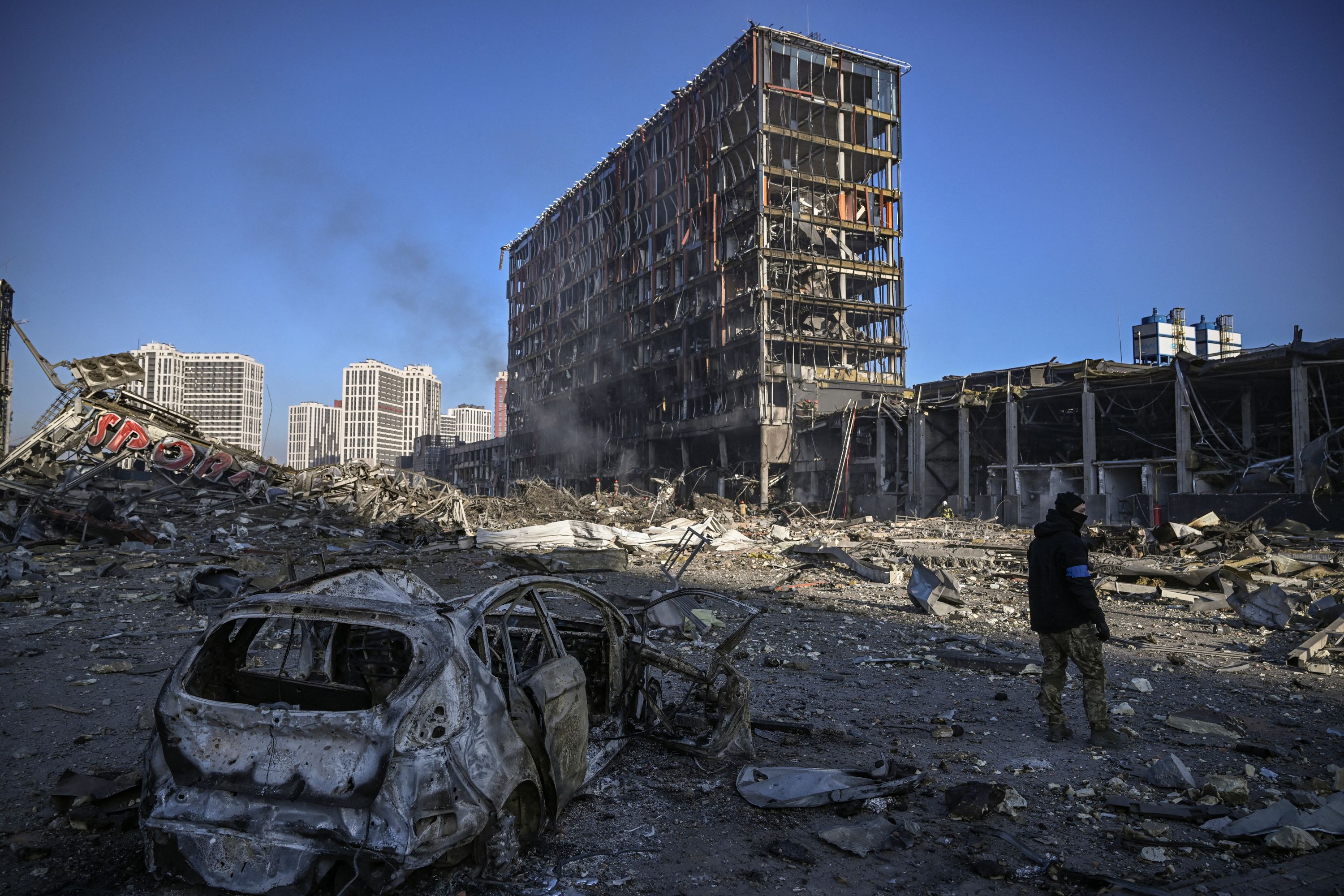 A Ukrainian serviceman walks through the debris outside the destroyed Retroville shopping mall in a residential district of Kyiv