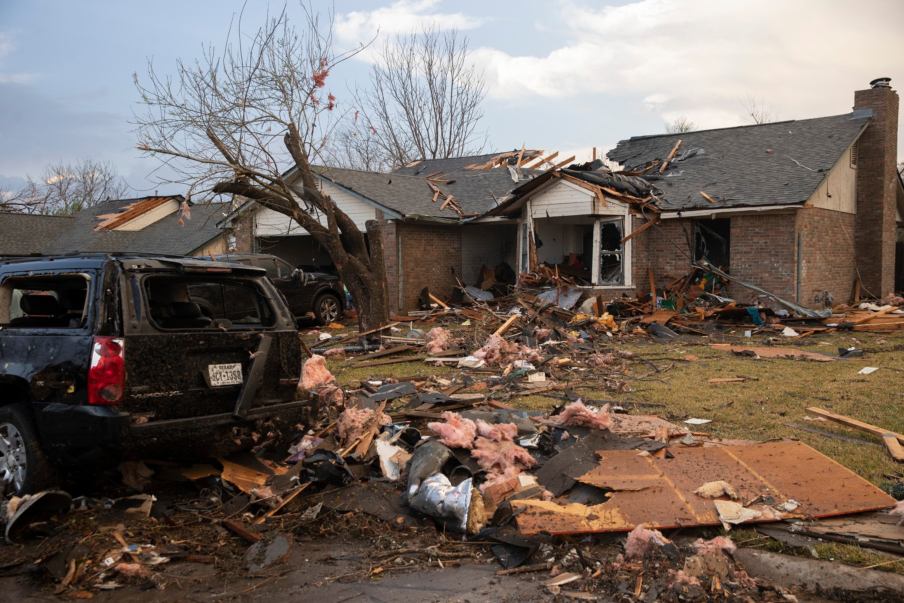 Debris litters the ground outside a house on Oxford Drive in Round Rock, Texas that was heavily damaged by a tornado