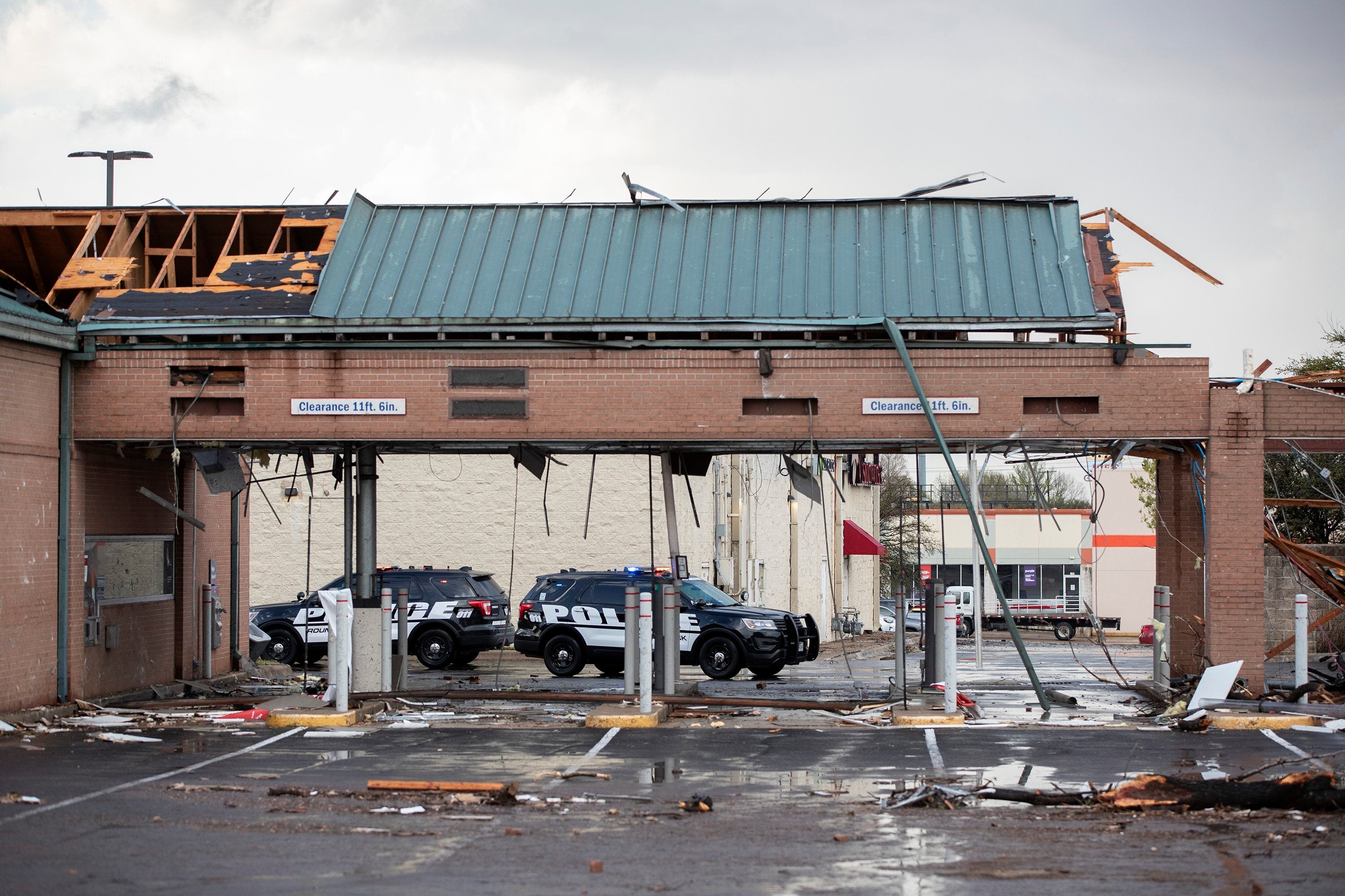 Police cars sit parked outside a bank, damaged by a tornado, near I-35 and SH 45 in Round Rock, Texas