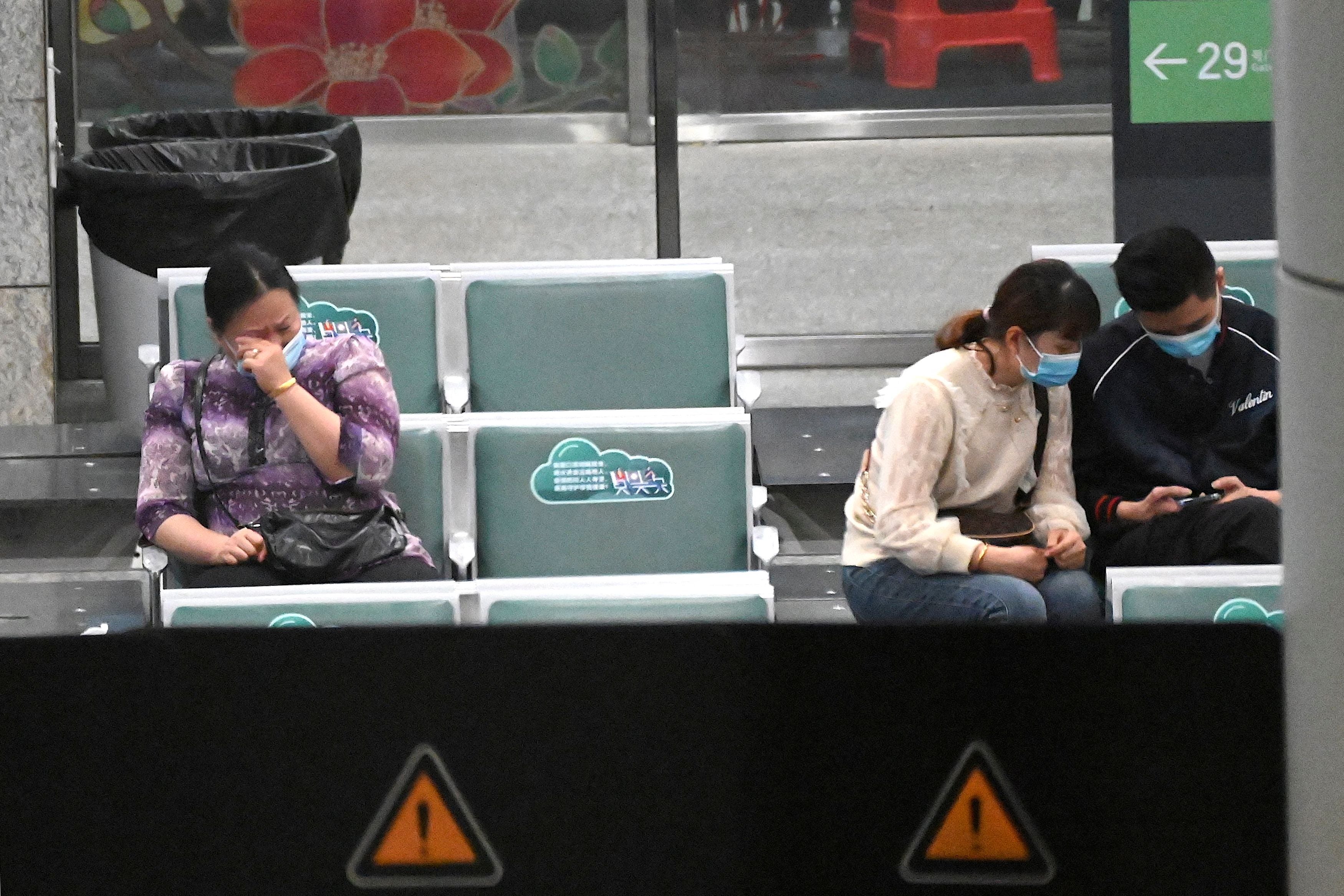 <p>Relatives of the passengers onboard China Eastern flight MU5735, which crashed onto a mountainside in southern China enroute to Guangzhou, sit at the holding area of the Guangzhou Baiyun International Airport in China’s southern Guangdong province, 21 March 2022</p>
