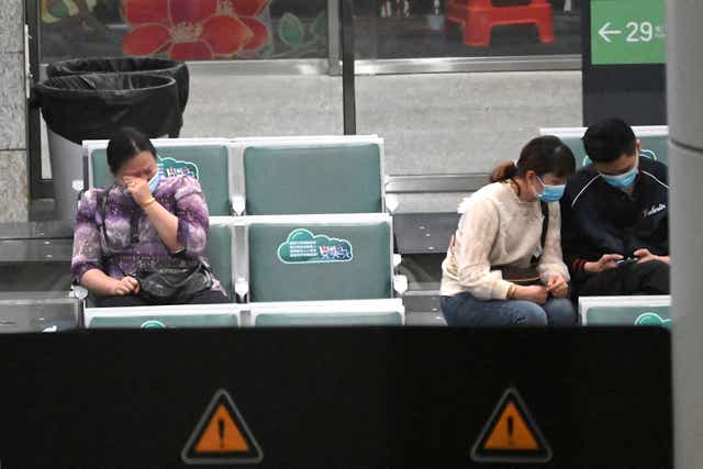 <p>Relatives of the passengers onboard China Eastern flight MU5735, which crashed onto a mountainside in southern China enroute to Guangzhou, sit at the holding area of the Guangzhou Baiyun International Airport in China’s southern Guangdong province, 21 March 2022</p>