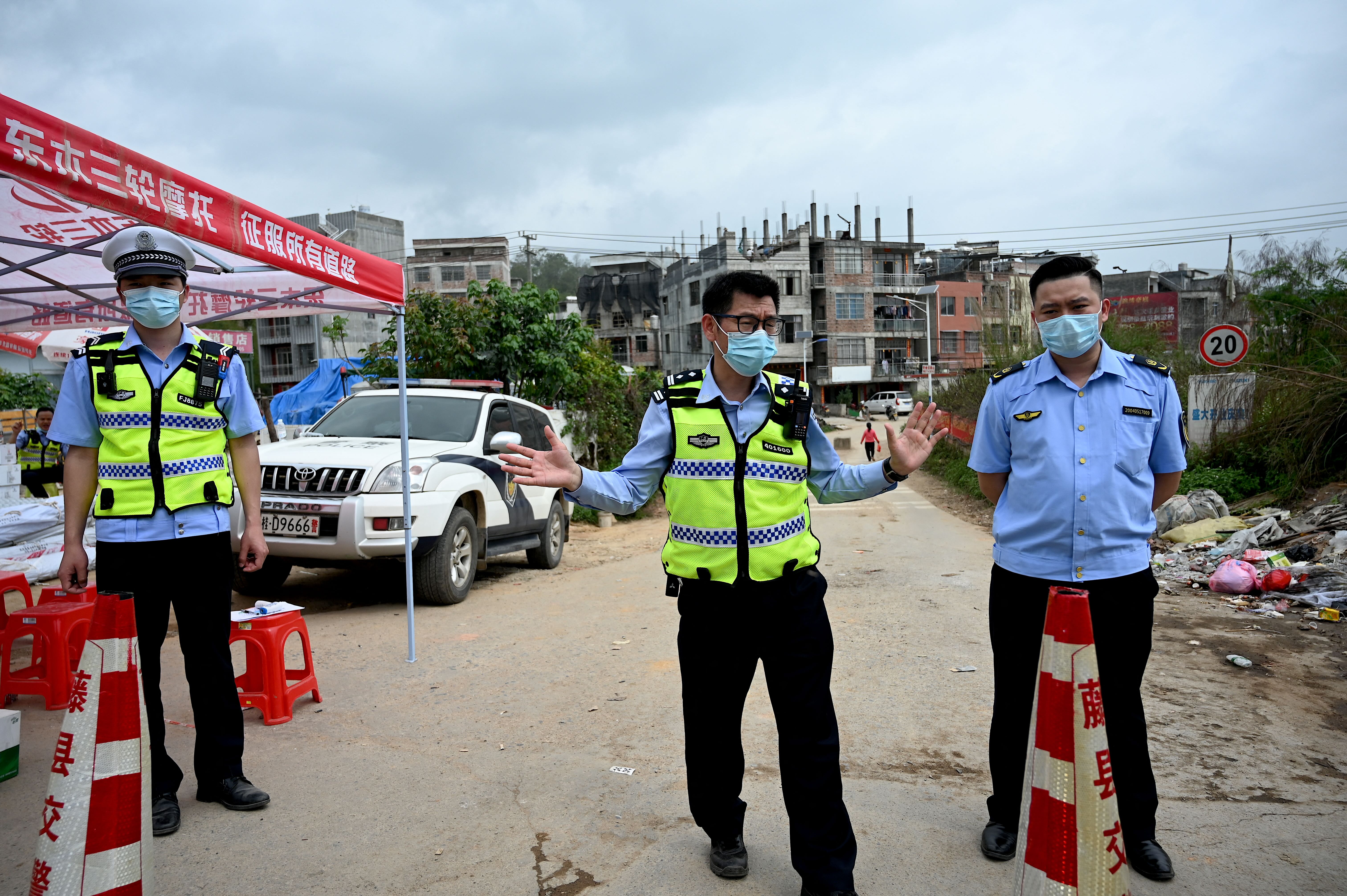 Policemen guard a checkpoint at Langnan village, in Wuzhou, near where the China Eastern flight MU5375 crashed 22 March 2022