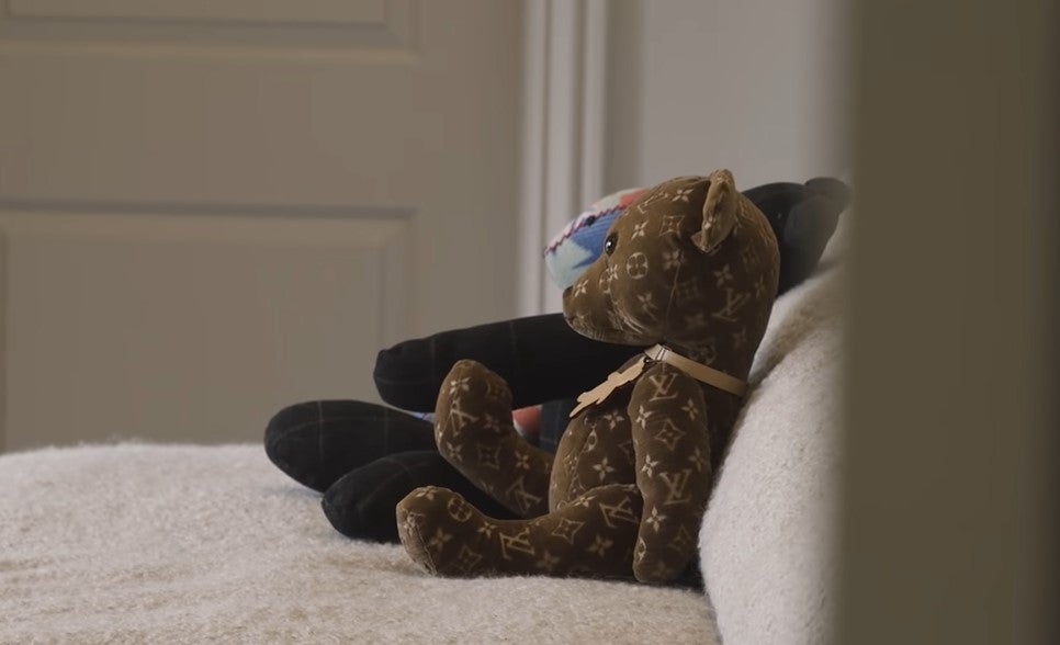 A limited edition Louis Vuitton teddy bear sits on the sofa