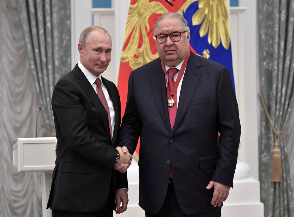 Alisher Usmanov (R) shakes hands with Russian president Vladimir Putin in 2018