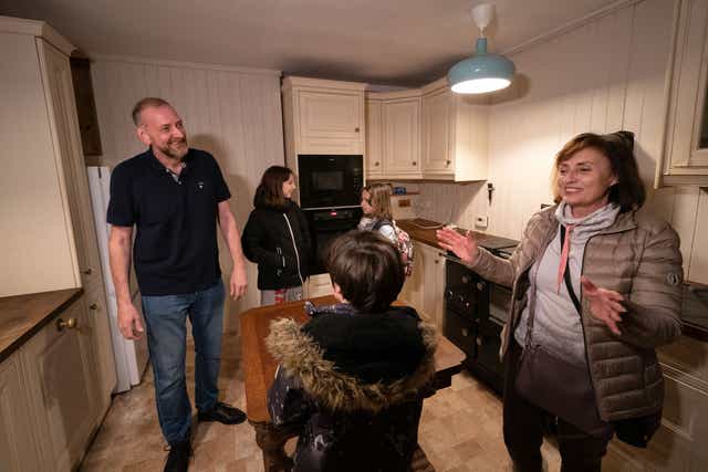 Businessman Mick Swinhoe shows Iryna Starkova and her grandchildren around the kitchen of their new home in Caldecote near Cambridge. (Joe Giddens/ PA)