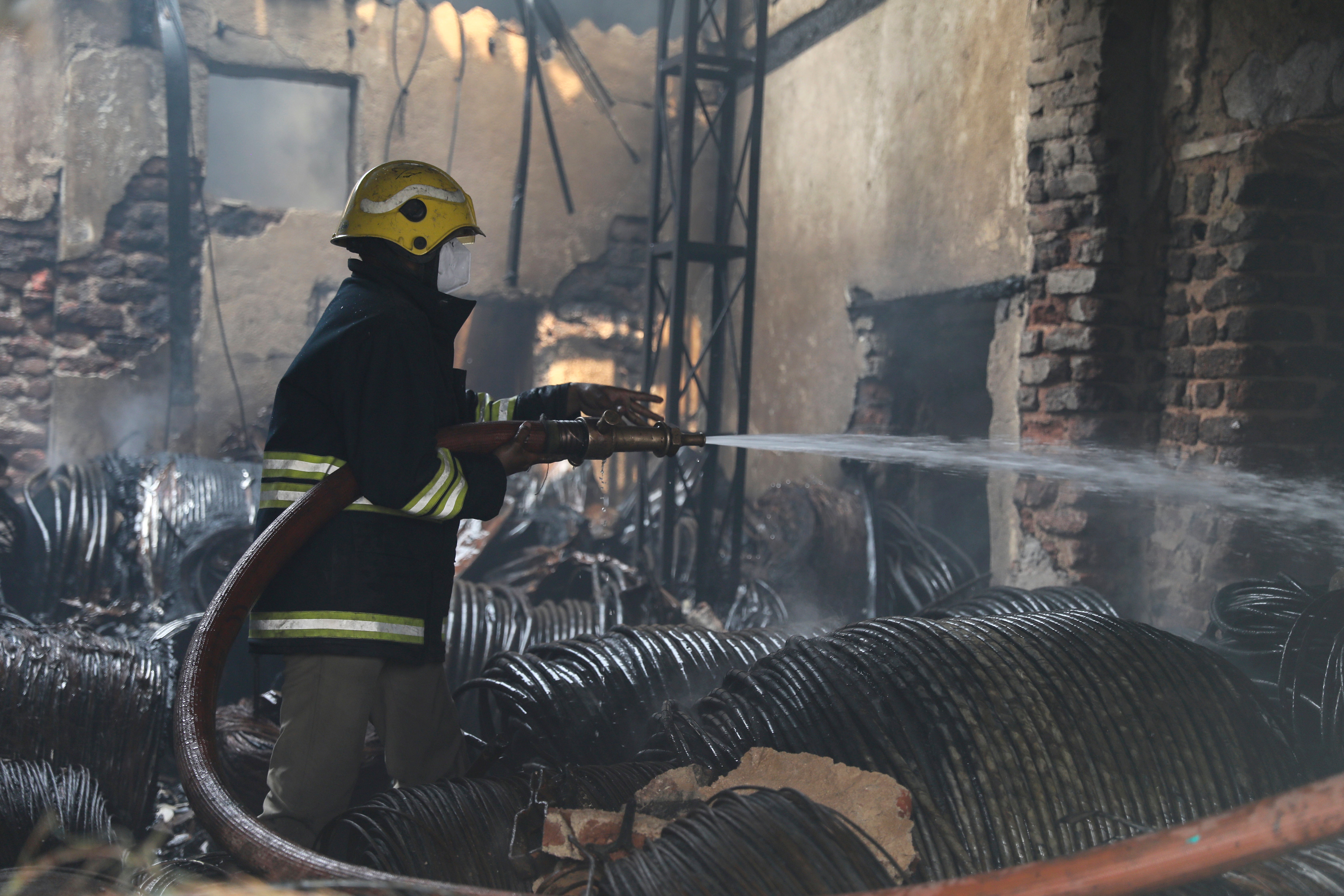 A fire man tries to douse a fire that broke out at a scrap warehouse in Hyderabad, India