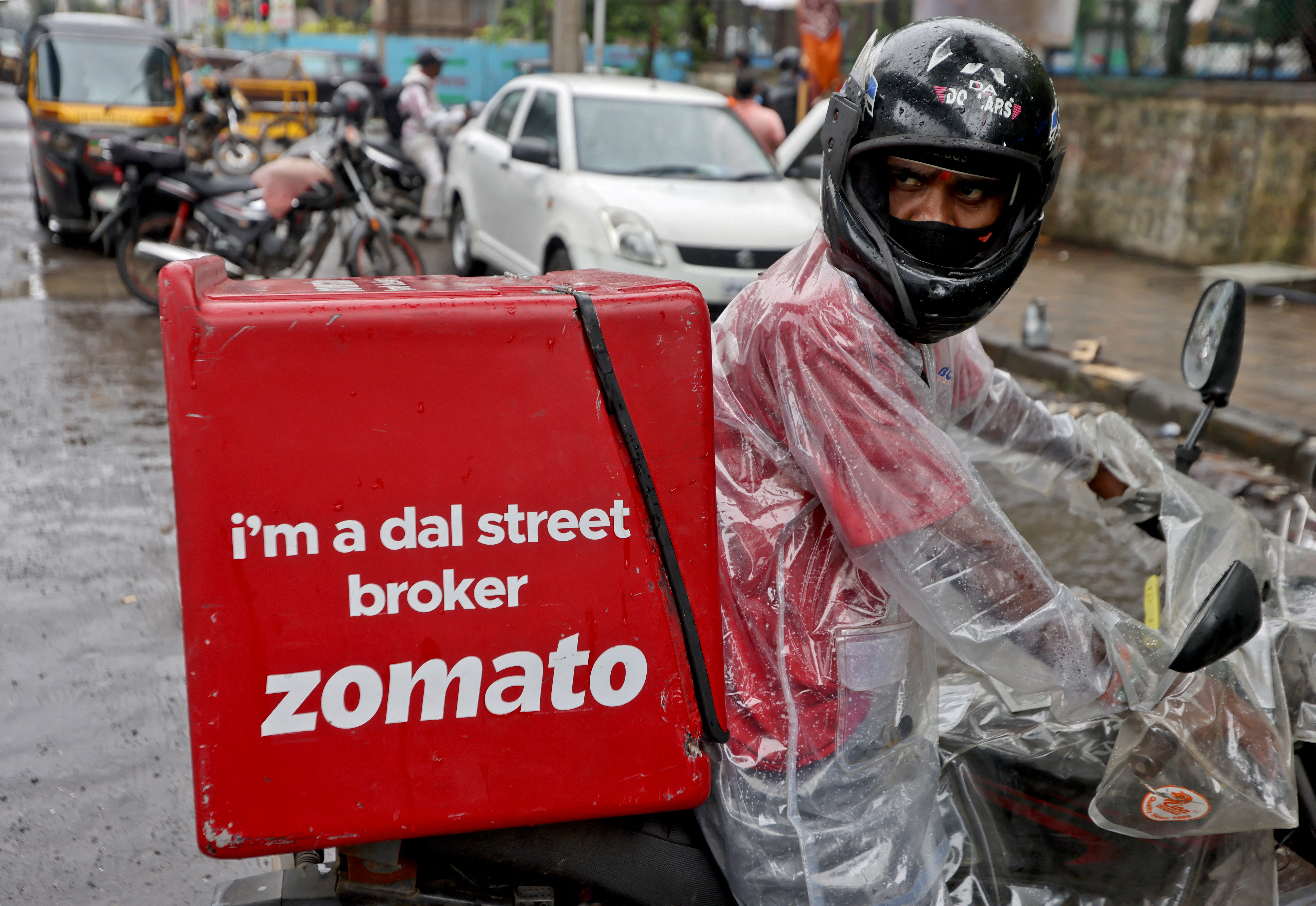 A delivery worker of Zomato, an Indian food-delivery startup, prepares to leave to pick up an order from a restaurant in Mumbai,