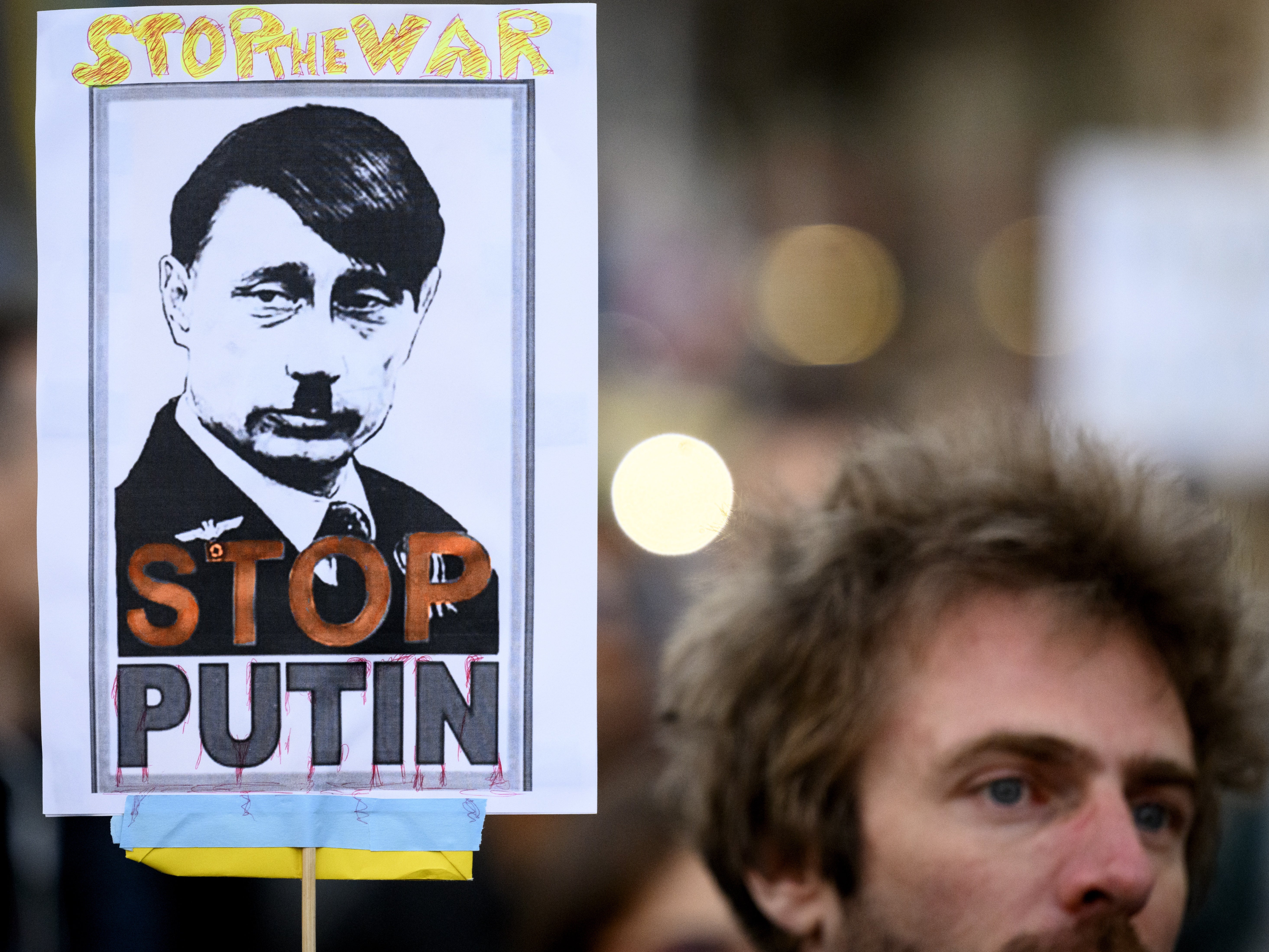 A protester carries a placard ‘Stop Putin’ during a demonstration against the Russian invasion of Ukraine on the sideline of the Financial Times Commodities Global Summit in Lausanne