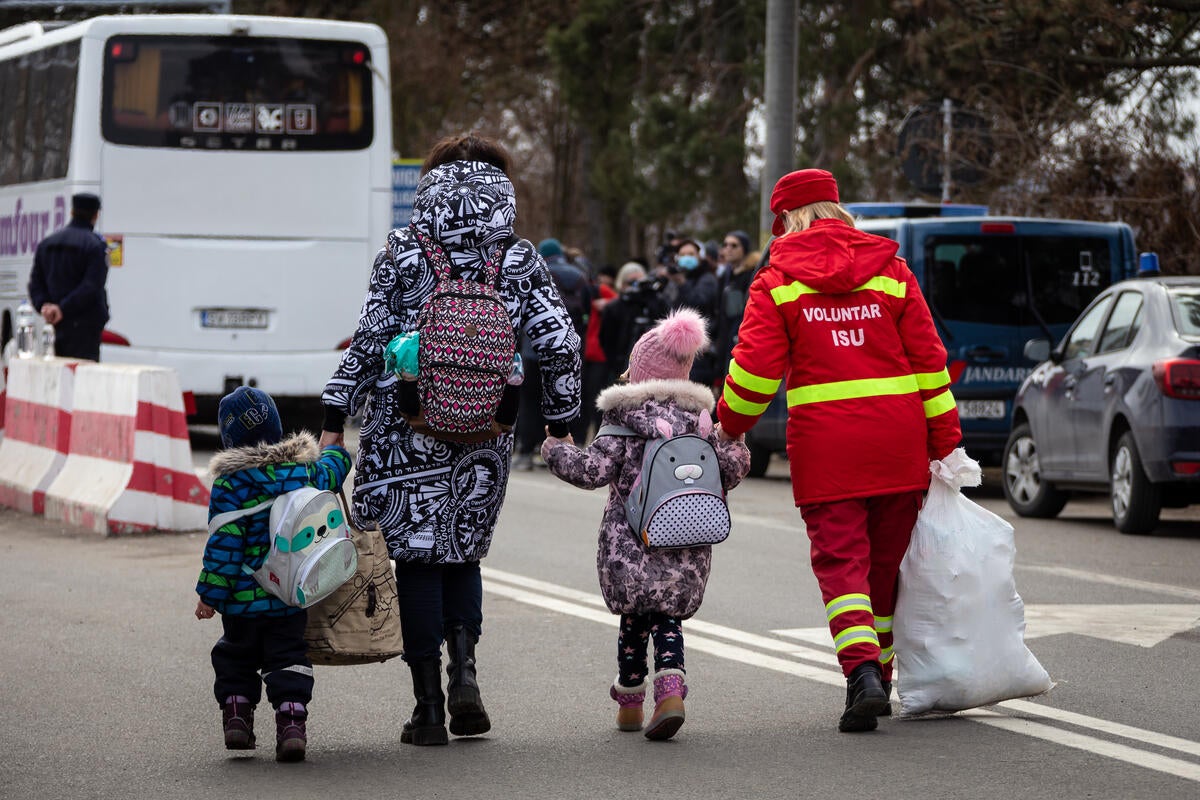 Ukrainian families and children cross the border into Romania to escape the crisis