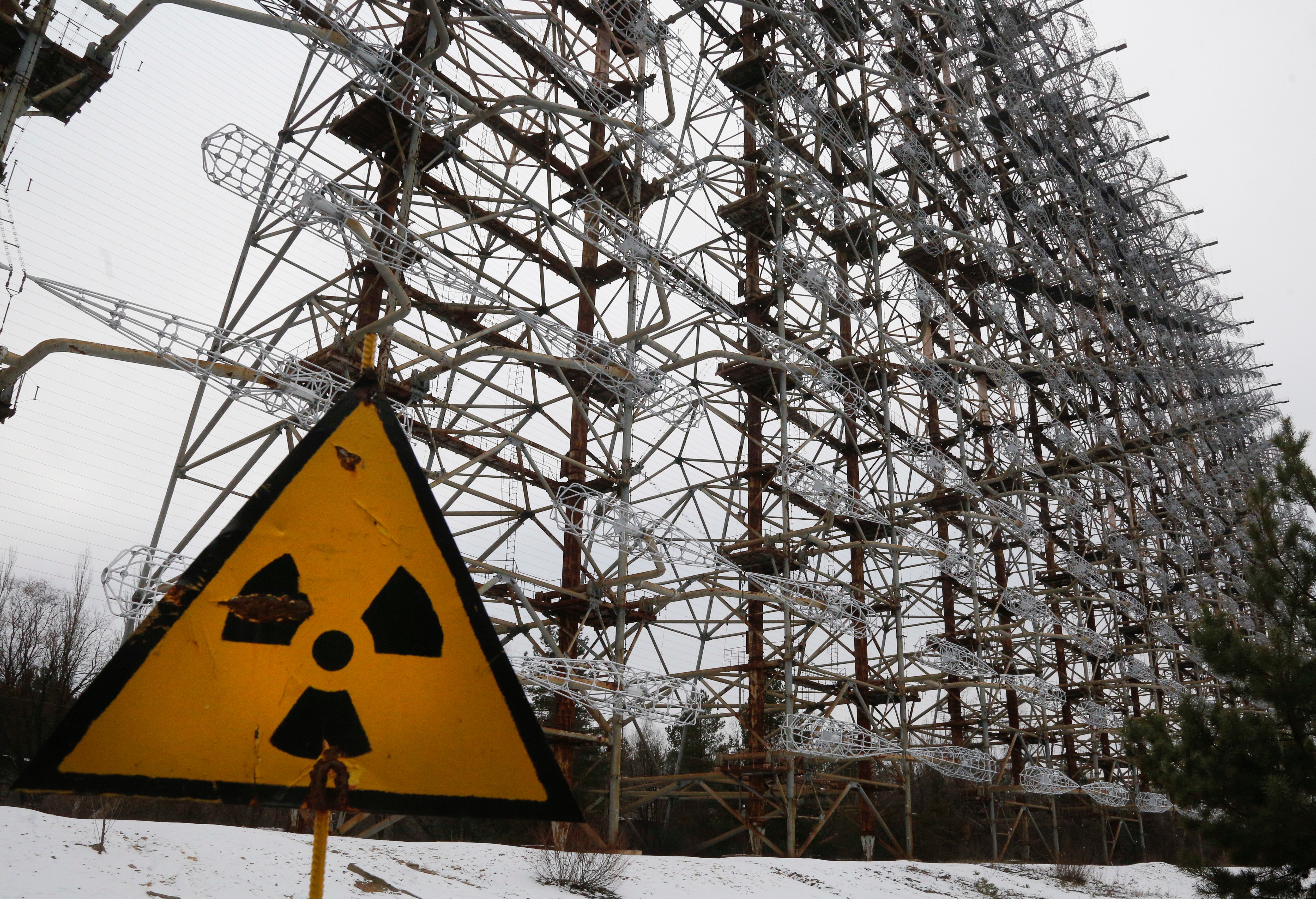 A Soviet-era radar system seen behind a radioactivity sign in Chernobyl