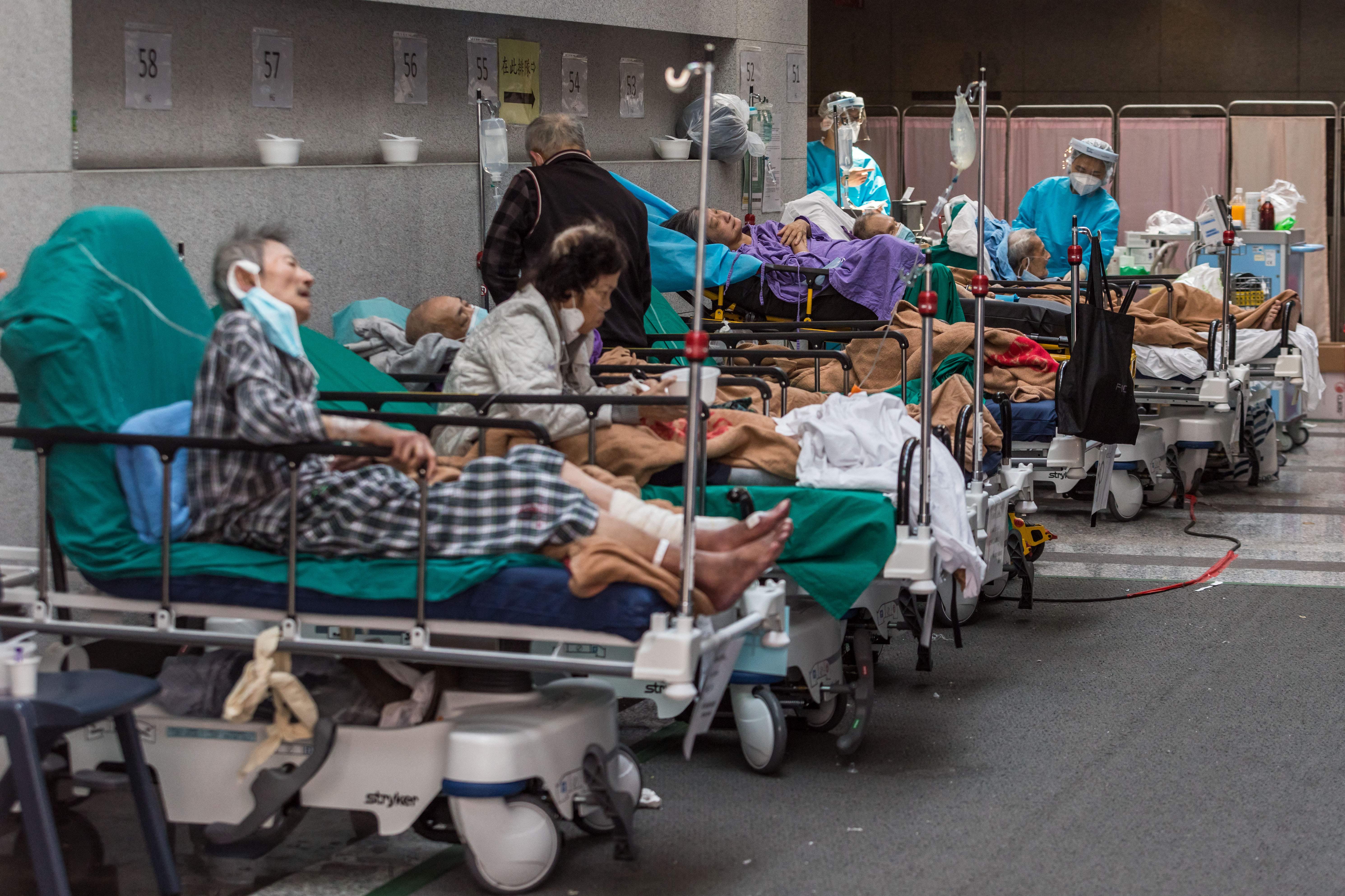Health workers treat patients in a holding area next to the A&E department of Princess Margaret hospital, 11 March 2022