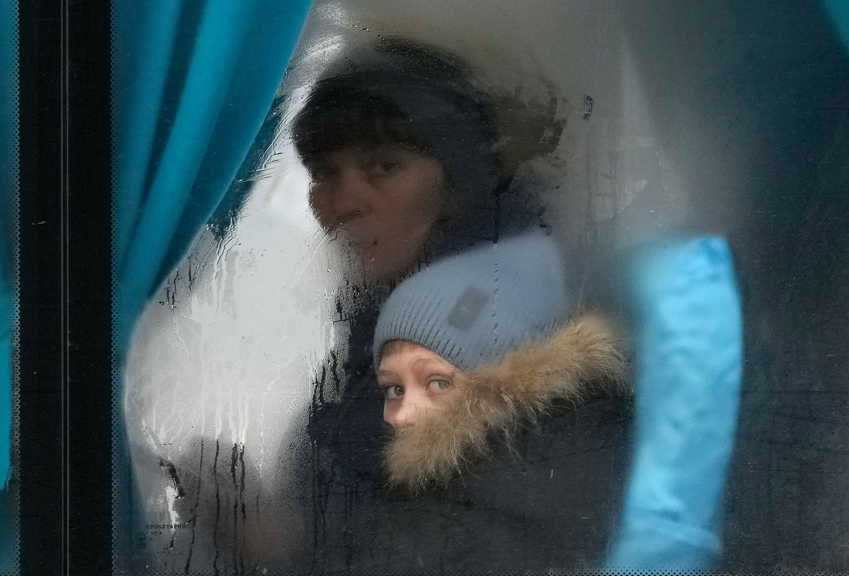 A woman and child peer out of the window of a bus as they leave Sievierodonetsk, the Luhansk region, eastern Ukraine