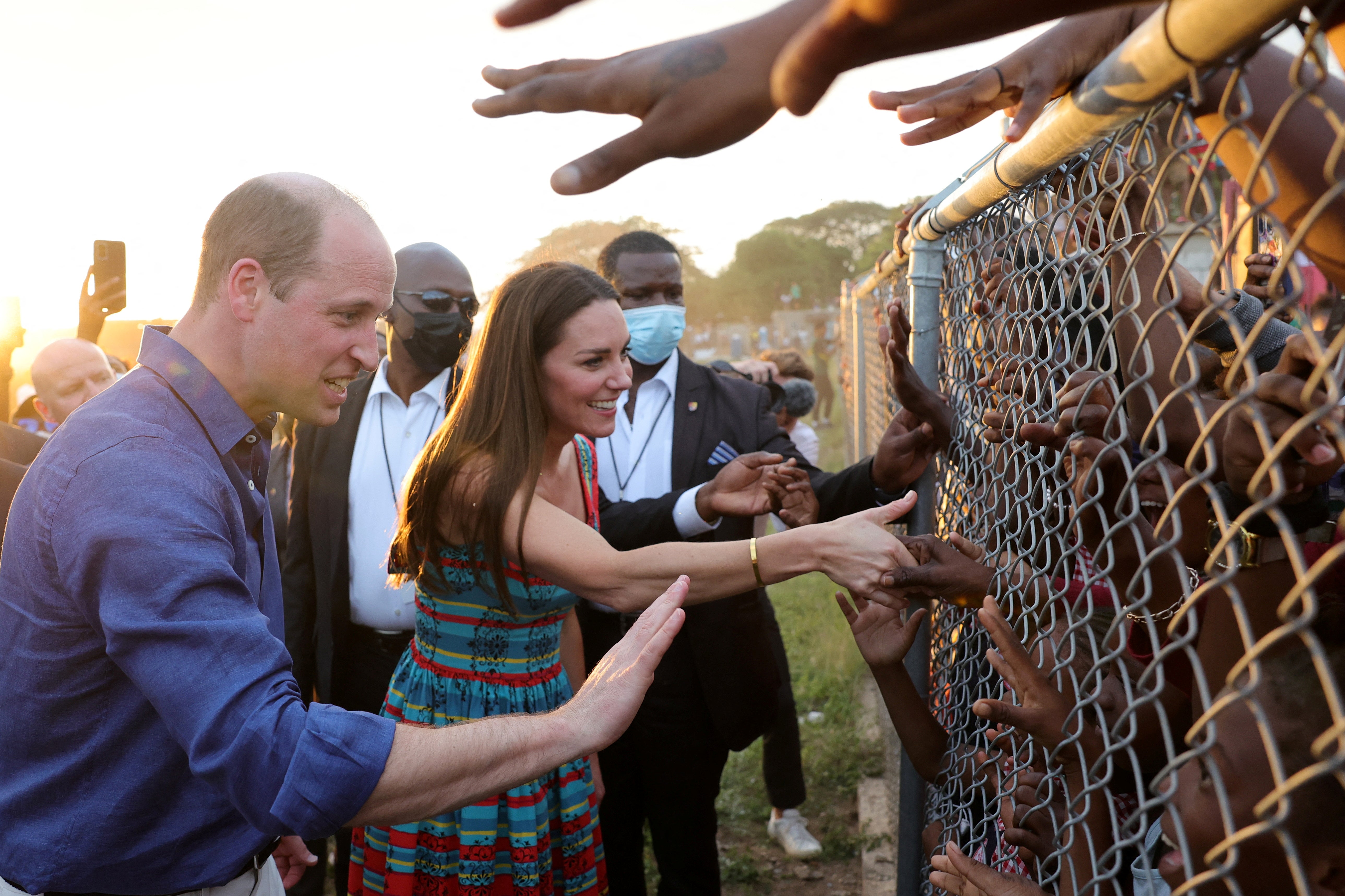 The pair were criticised after this photo, as they shake hands with children behind a fence during a visit to Trench Town, Jamaica