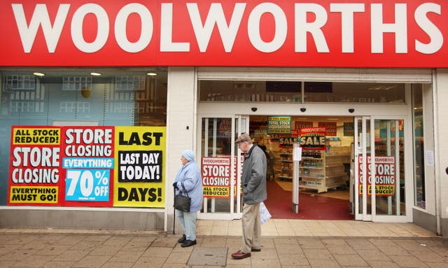 <p>Shoppers pass a Woolworths shop on it's last day of trading on December 27, 2008 in New Malden, London</p>